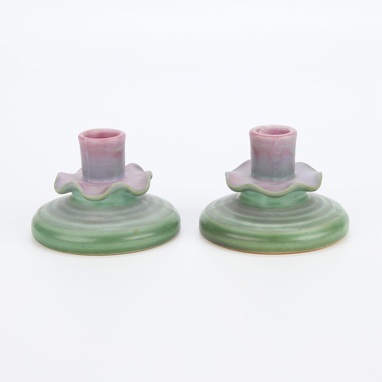Pair Vintage Weller Pottery "Fleron" Candlesticks: Pair of vintage Weller Pottery "Fleron" line candlesticks. Glazed matte green along the footrim and magenta along the candlestick cup. With undulating rim and ribbed texture along the exteri