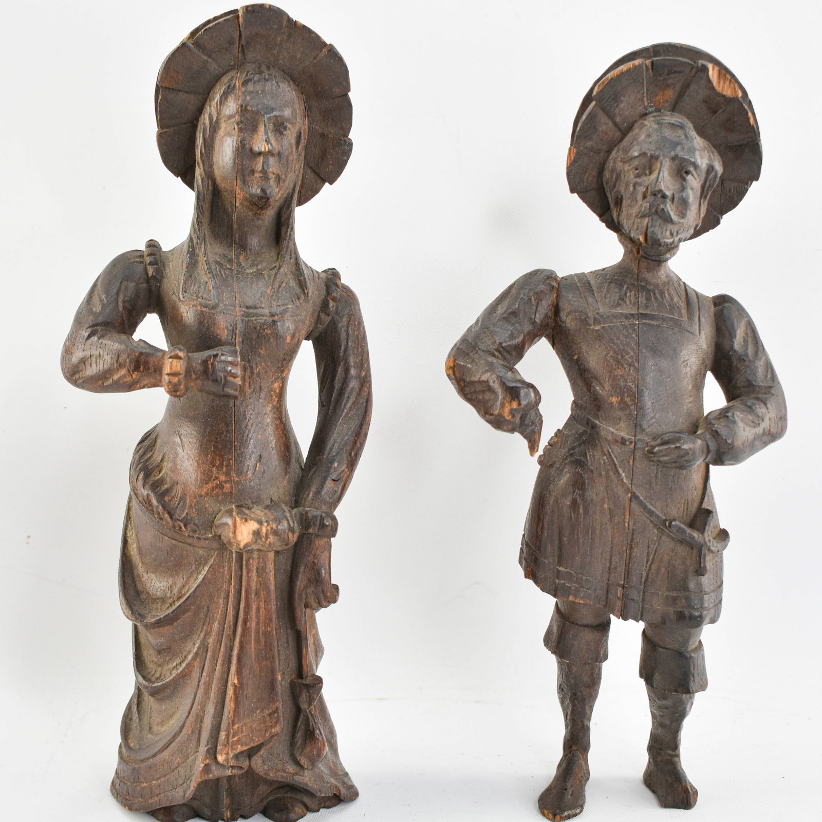 Pair 19th C. Carved Oak Folk Art Figures: Two 19th Century folk art figures - a man and a woman - hand carved from oak wood. Large holes in back of figures indicate they were likely mounted originally. 11"H x 4"W x 2.5"D, each.