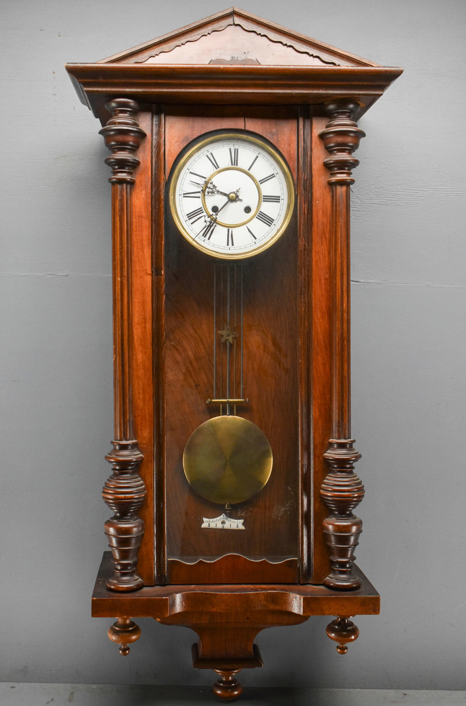 Antique Victorian Wall Clock: Antique Victorian wall clock with wood body and porcelain face. Includes pendulum, key, and two pieces of trim that are currently unattached. Clock is untested, sold as is.42"H x 18"W x 10&q