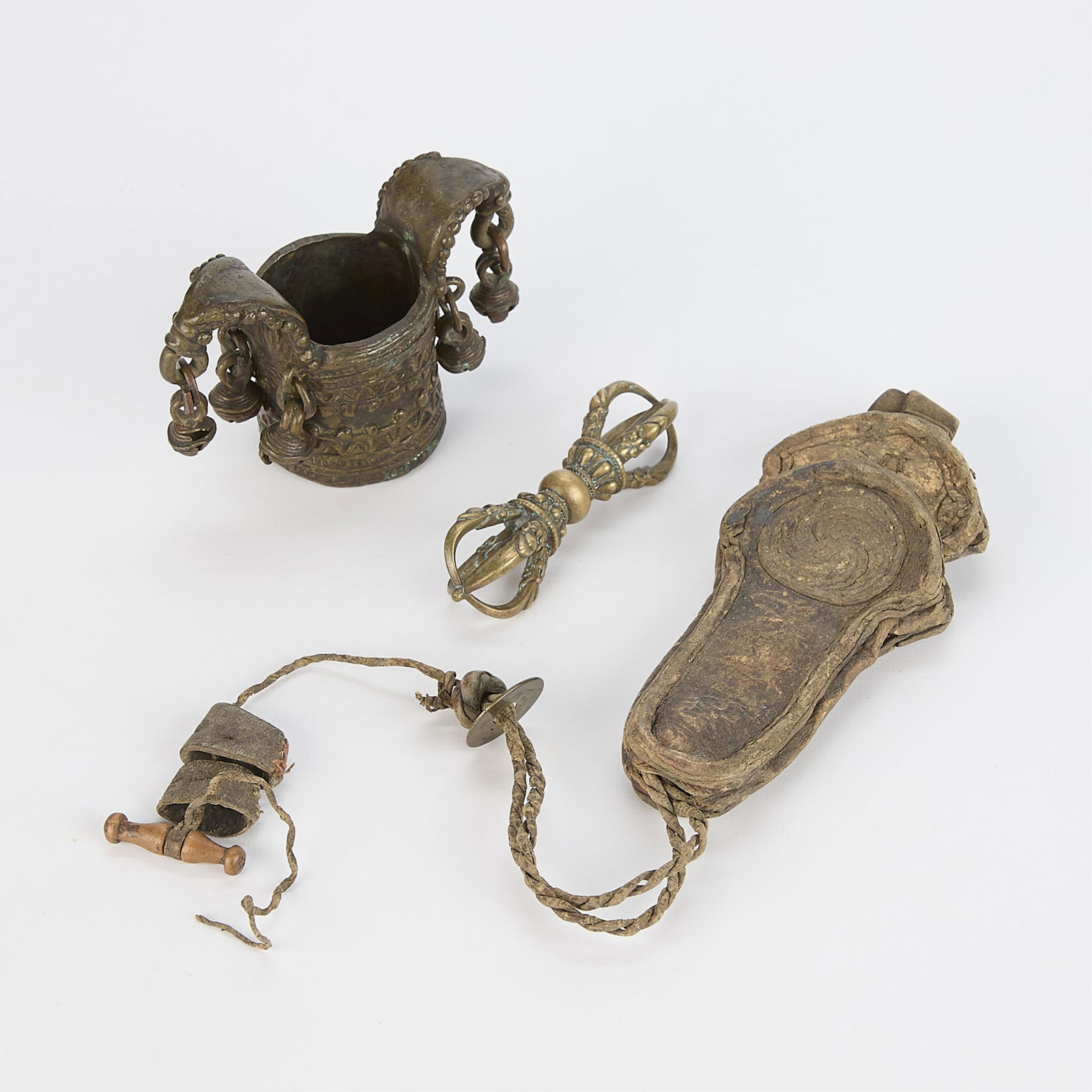 Grp 3 Antique Tibetan Objects: Group of three antique Tibetan items including a bronze lobed cylindrical cuff, a small dorje thunderbolt scepter, and a leather or hide object with string, possibly a needle case.(Largest) 5"L x