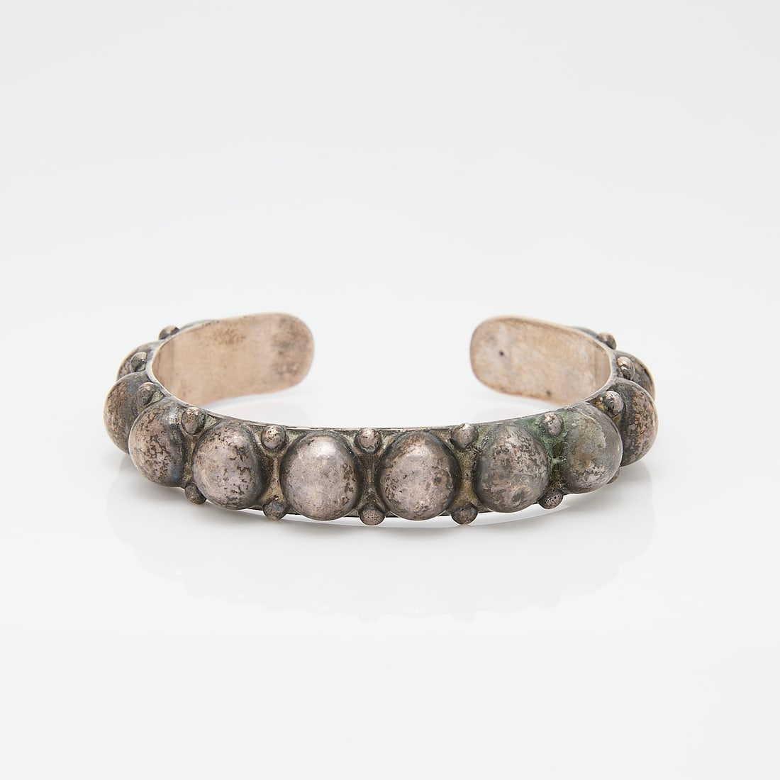 Southwest Silver Cuff: Southwest silver cuff with raised orb-like design and crossed arrows. Appears unmarked.Gross weight: Approximately 30g