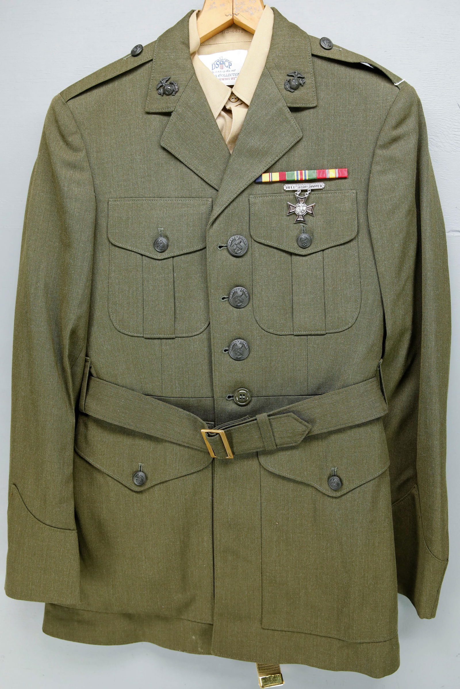 Modern Era U.S. Marines Dress Green Uniform: A modern U.S. Marines dress green uniform including shirt, trousers, belt, tie and coat. With a Rifle Sharpshooter pin and service medal ribbons. Comes in a denim garment bag.
