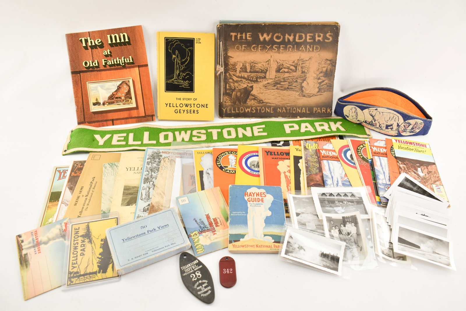 Vintage Yellowstone National Park Ephemera & Collectibles: Lot includes a variety of epherma and collectibles including books, a hat, a felt banner, maps, handbooks, guidebooks, photographs, hotel key tags, and more! Largest book: 10.25"H x 13.25"W.
