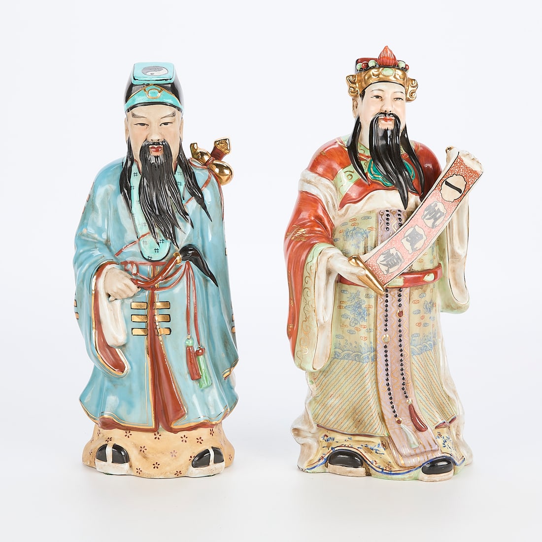 2 Asian Porcelain Figures: Group of two Asian porcelain figures of men. Blue; height: 12 1/2 in x width: 5 in x depth: 4 in. Red; height: 13 in x width: 6 in x depth: 4 1/2 in.