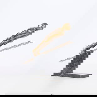 Bronze Ski Jumper Sculpture: Bronze sculpture of a competitive skier in goggles nearly parallel with their skis mounted atop a black stone base. The piece was likely inspired by the work of sculptor Mario Nick12"H x 8"L x 3.5"W.