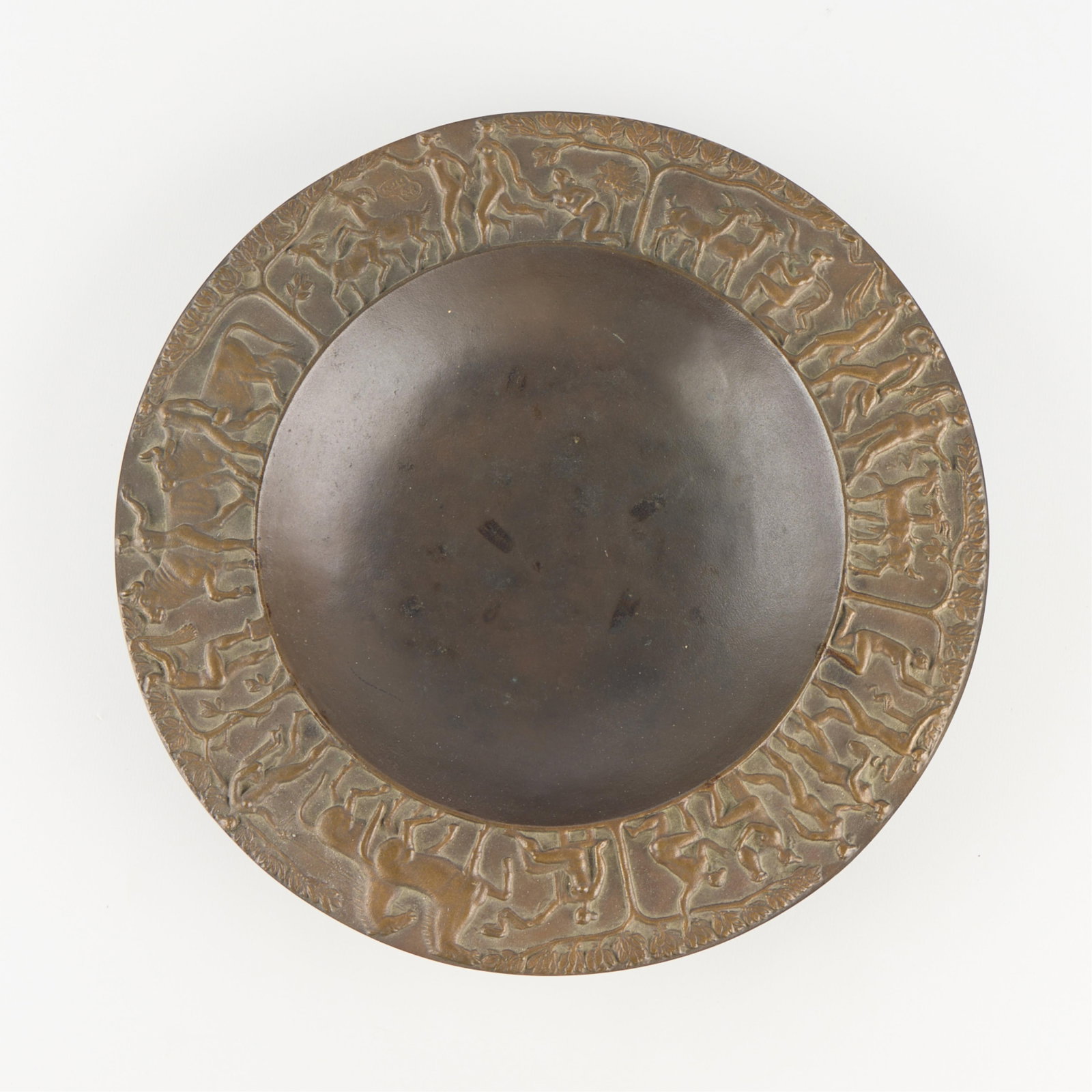 Fritz Nuss Bronze Decorative Bowl: Bronze dish decorated with detailed reliefs of figures and animals along the rim. Signed "Nuss 48" along the rim.Height: 1 1/2 in x diameter: 12 in.