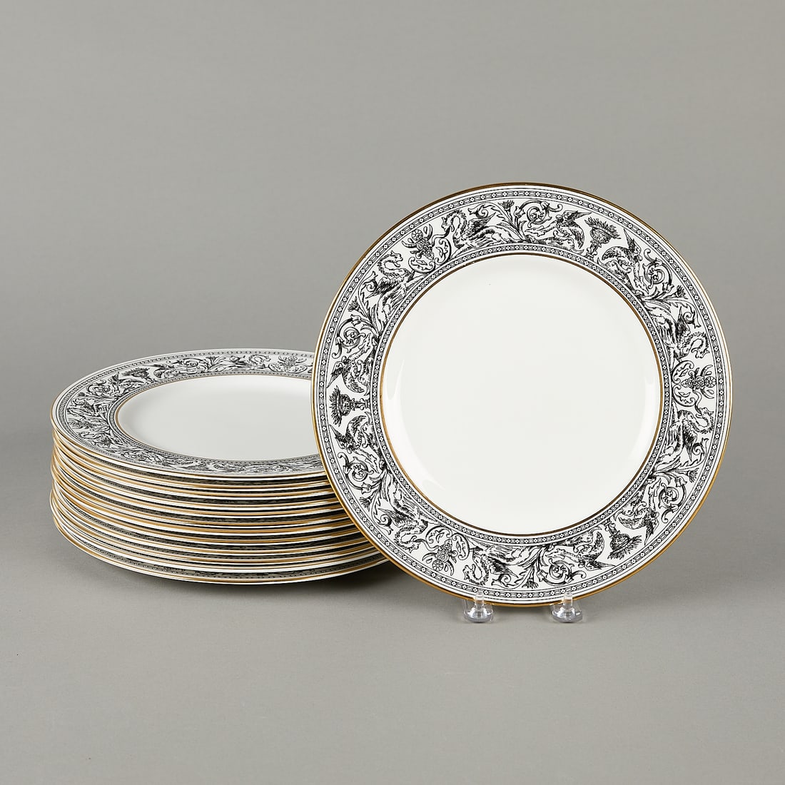 13 Wedgwood Florentine Dinner Plates: Set of 13 Wedgwood dinner plates in pattern "Florentine." Decorated with detailed black and white mythical motifs and gilt rims.EACH: 10 3/4"Dia.
