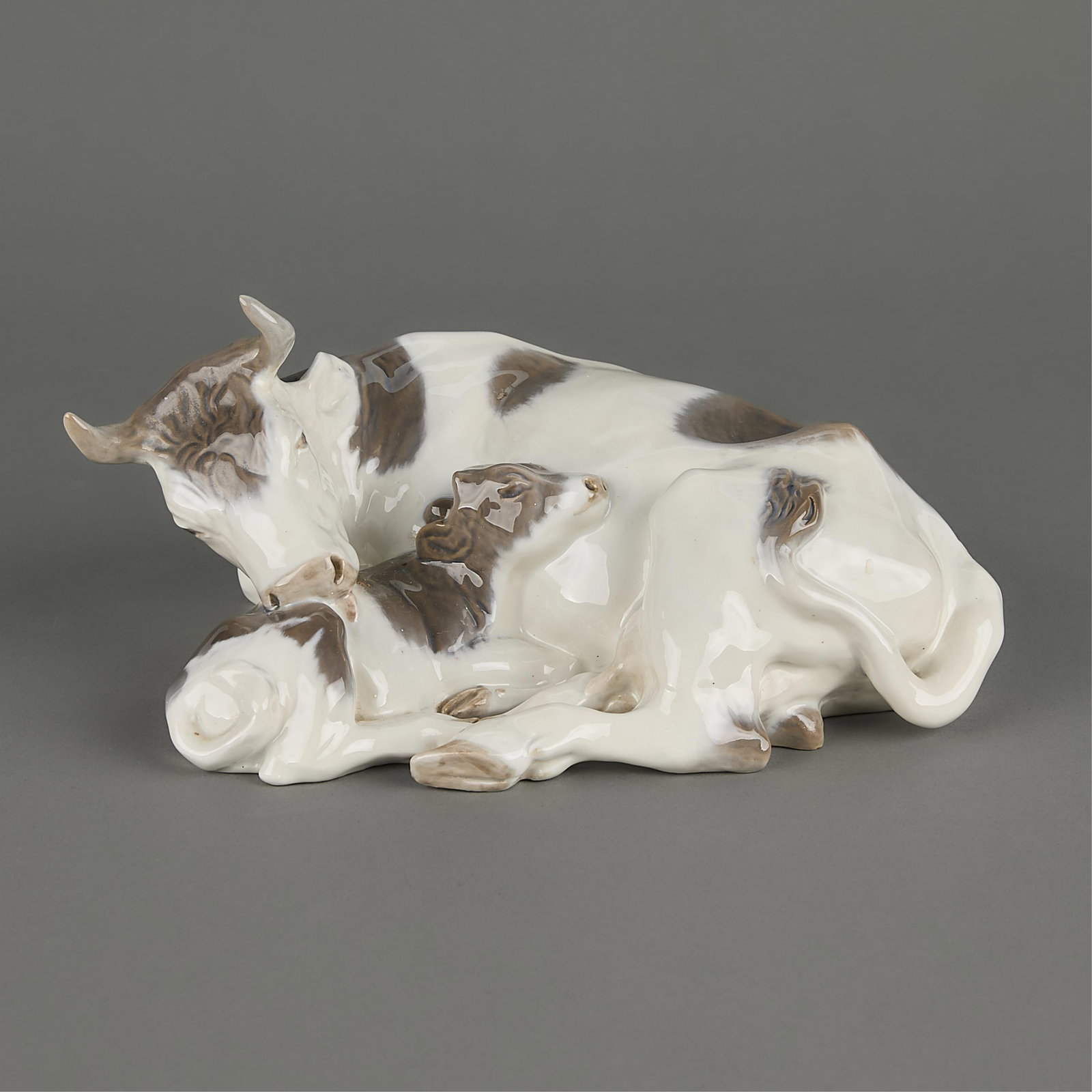 Royal Copenhagen 800 "Cow with Calf" Figurine: Royal Copenhagen figurine design by Knud Kyhn of a cow and calf laying down. Marked on underside.3"H x 10 3/4"W x 7 3/4"D.