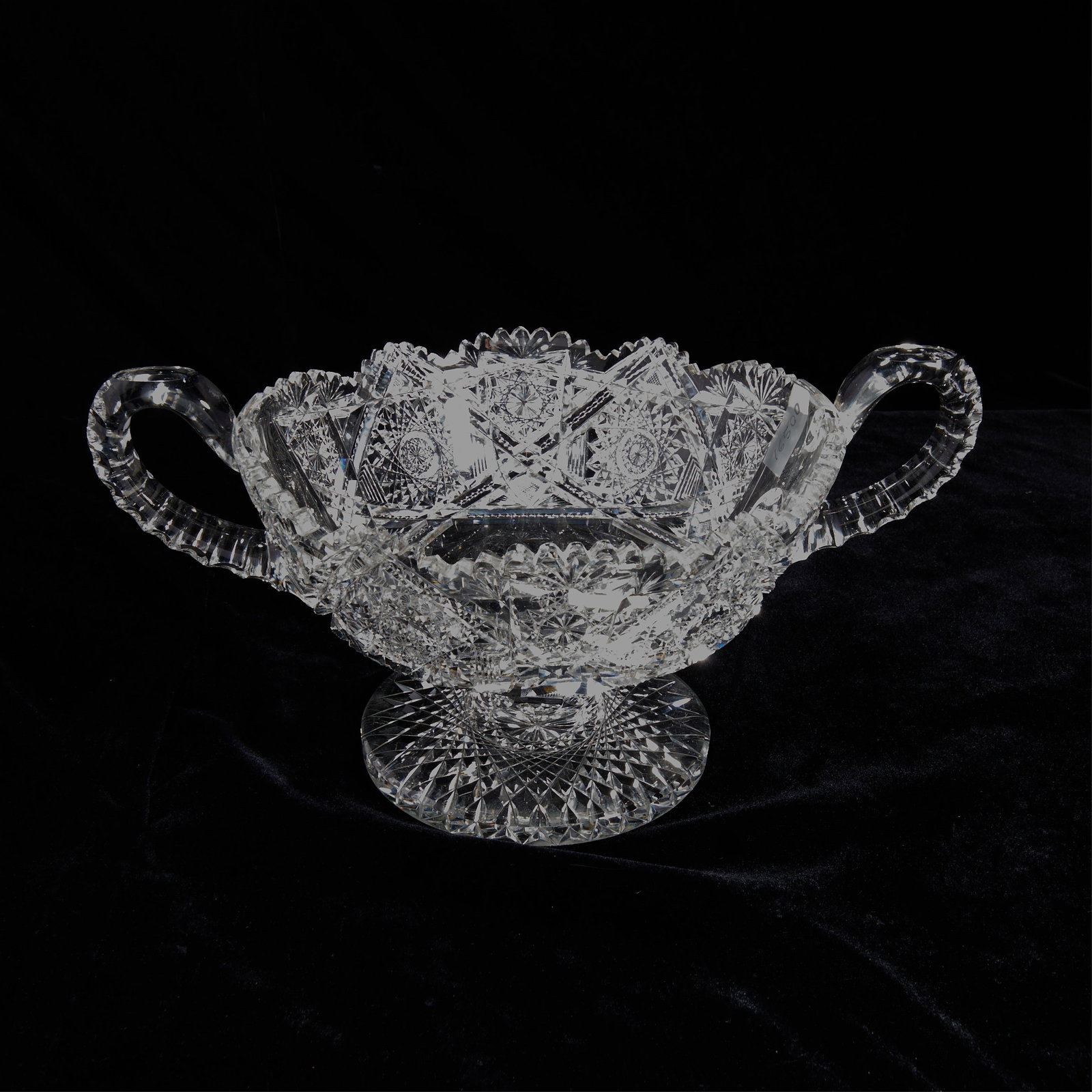 Cut Glass Crystal Handled Bowl: Cut glass or crystal two-handled footed bowl.Height: 7 in x width: 13 1/2 in x diameter: 9 in.