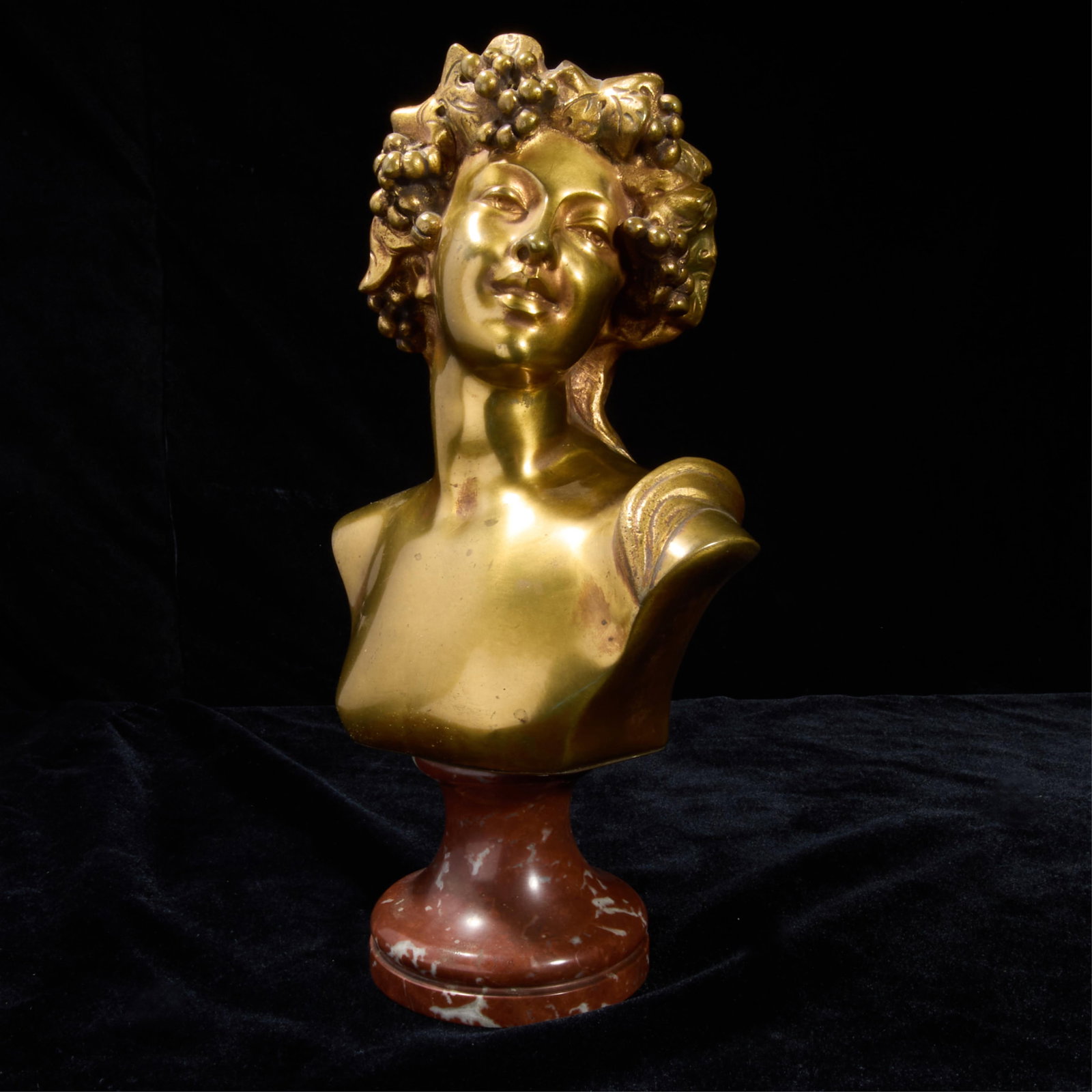 Bronze Bust Jef Lambeaux w/ Marble Base: Bronze bust of a jovial youth. Incised "Jef Lambeaux" along the shoulder. With a red marble base.Height: 12 in x width: 7 in x depth: 5 in.