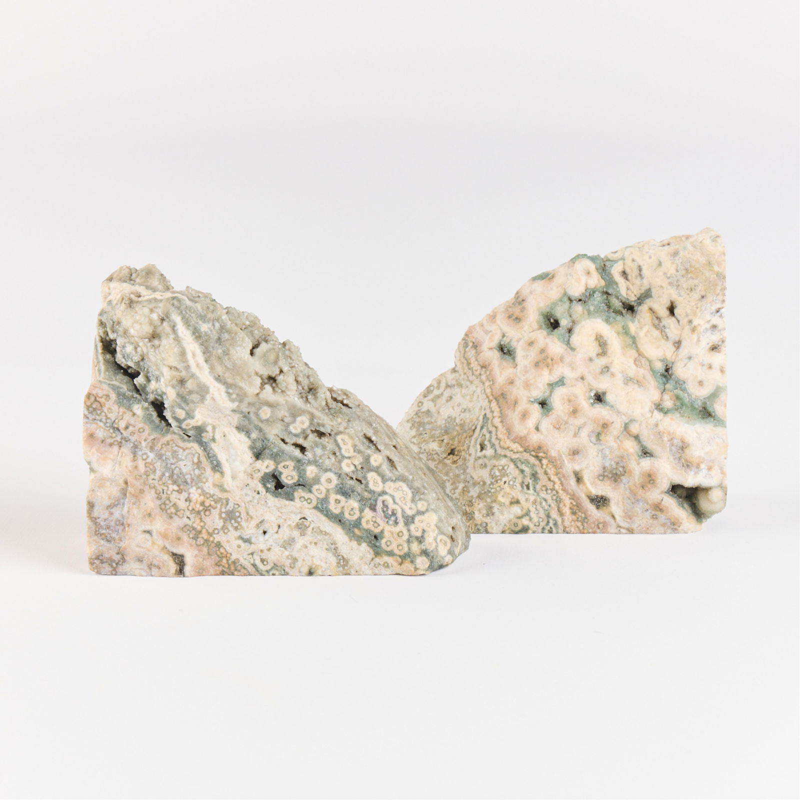 2 Madagascar Ocean Jasper Rock Bookends: Set of two ocean jasper bookends. Each with three polished sides and two rough sides.Height: 4 1/2 in x width: 4 in x depth: 2 in.