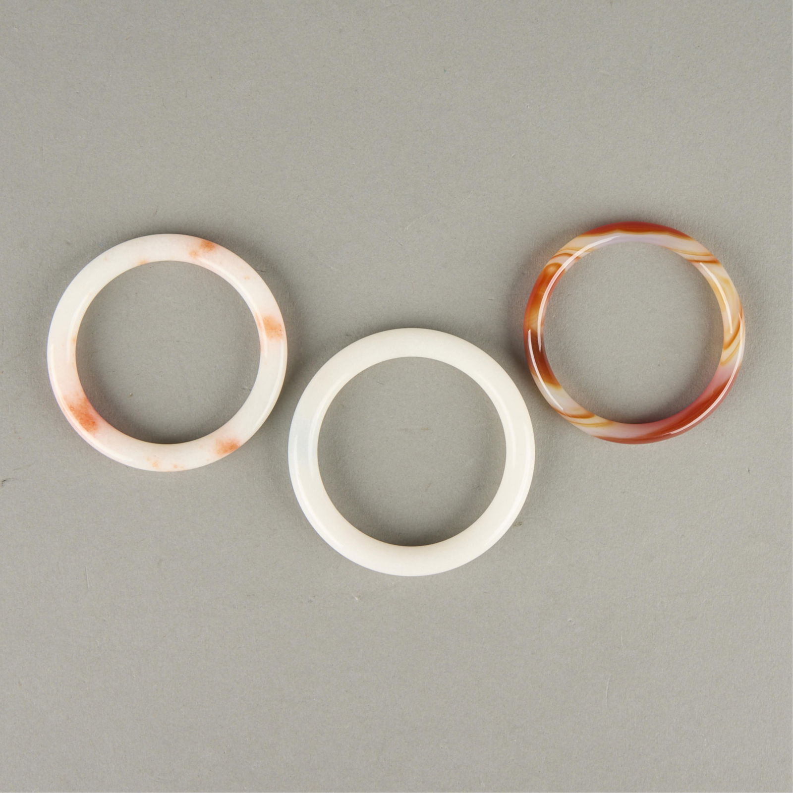 3 Chinese Jade Bangles: Group of three Chinese jade bangles.Inner diameter ranges from 2 1/4 in to 2 3/8 in; outer diameter ranges from 2 3/4 in to 3 in. Gross weight: 89.6 g.