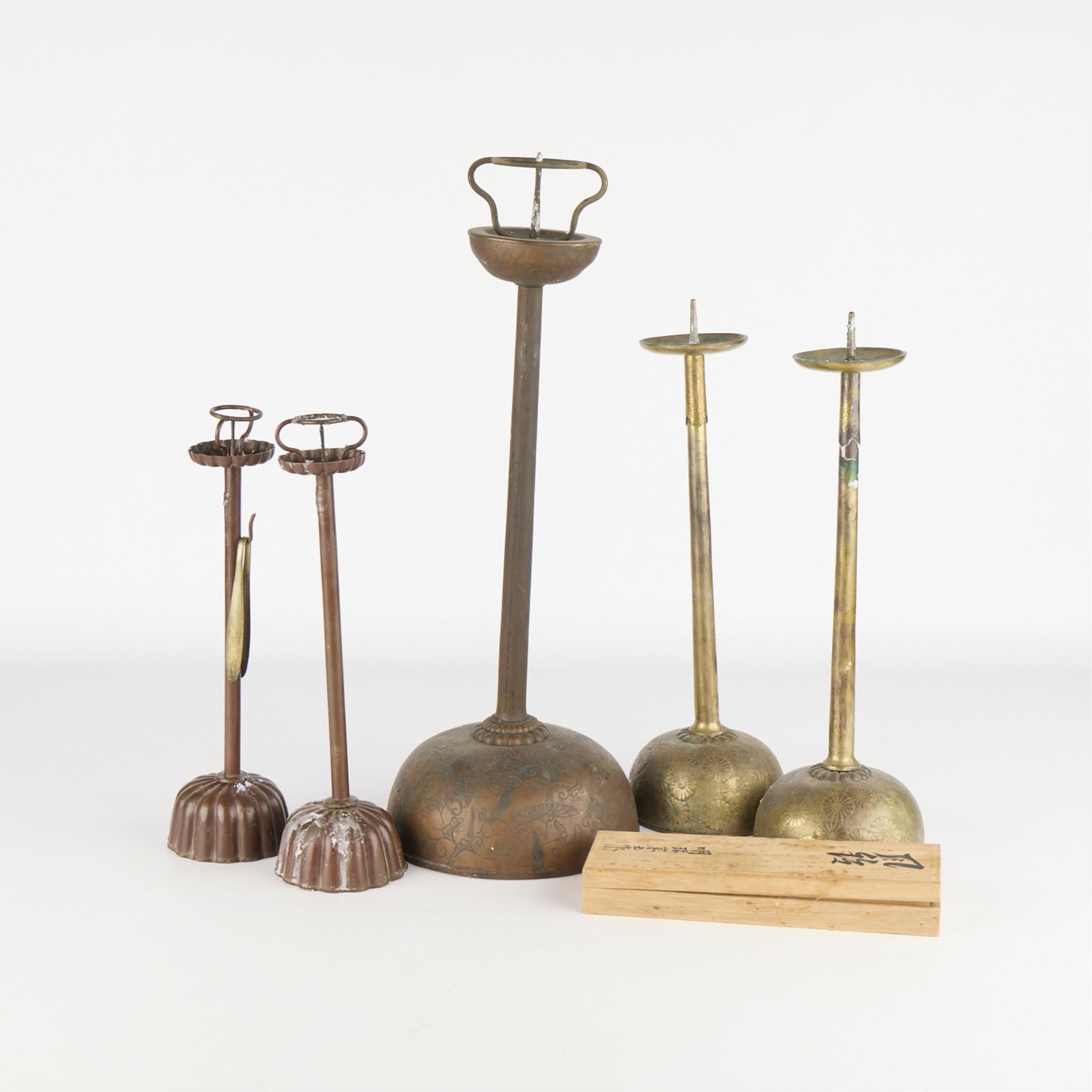 5 Japanese Metal Candlesticks: Group of five Japanese brass or bronze metal candle stick holders.Height ranges from 13 1/2 in to 21 in; diameter ranges from 3 3/4 in to 7 1/2 in.