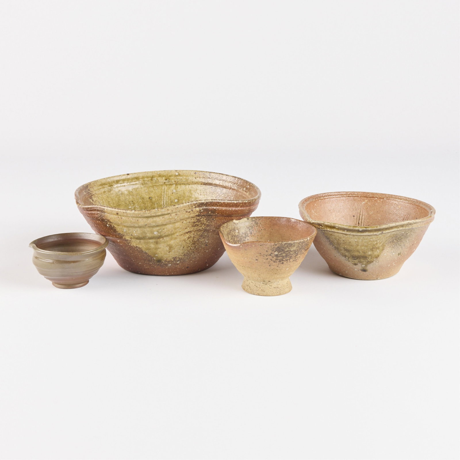 4 Nesting Japanese Pouring Bowls: Set of four nesting Japanese pouring bowls. Each marked along the underside. Height ranges from 1 3/4 in to 3 1/4 in; diameter ranges from 3 1/2 in to 8 1/4 in.
