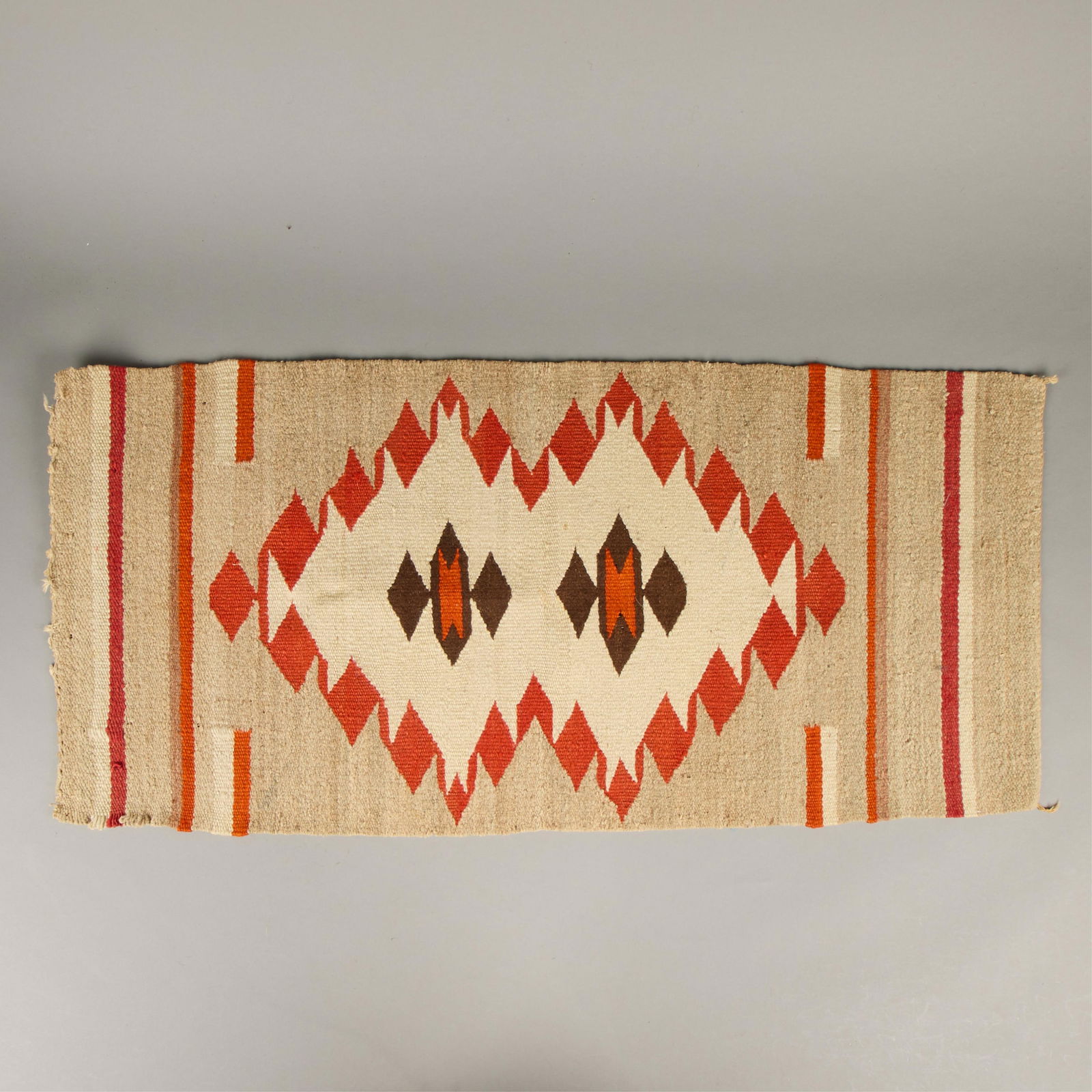 20th c. Navajo Wool Double Saddle Blanket: Dine (Navajo) wool double saddle blanket or rug textile, 20th century. The carpet with central field of angular geometric motifs against cream. Executed in reds, orange, and brown, Resembling vibrant