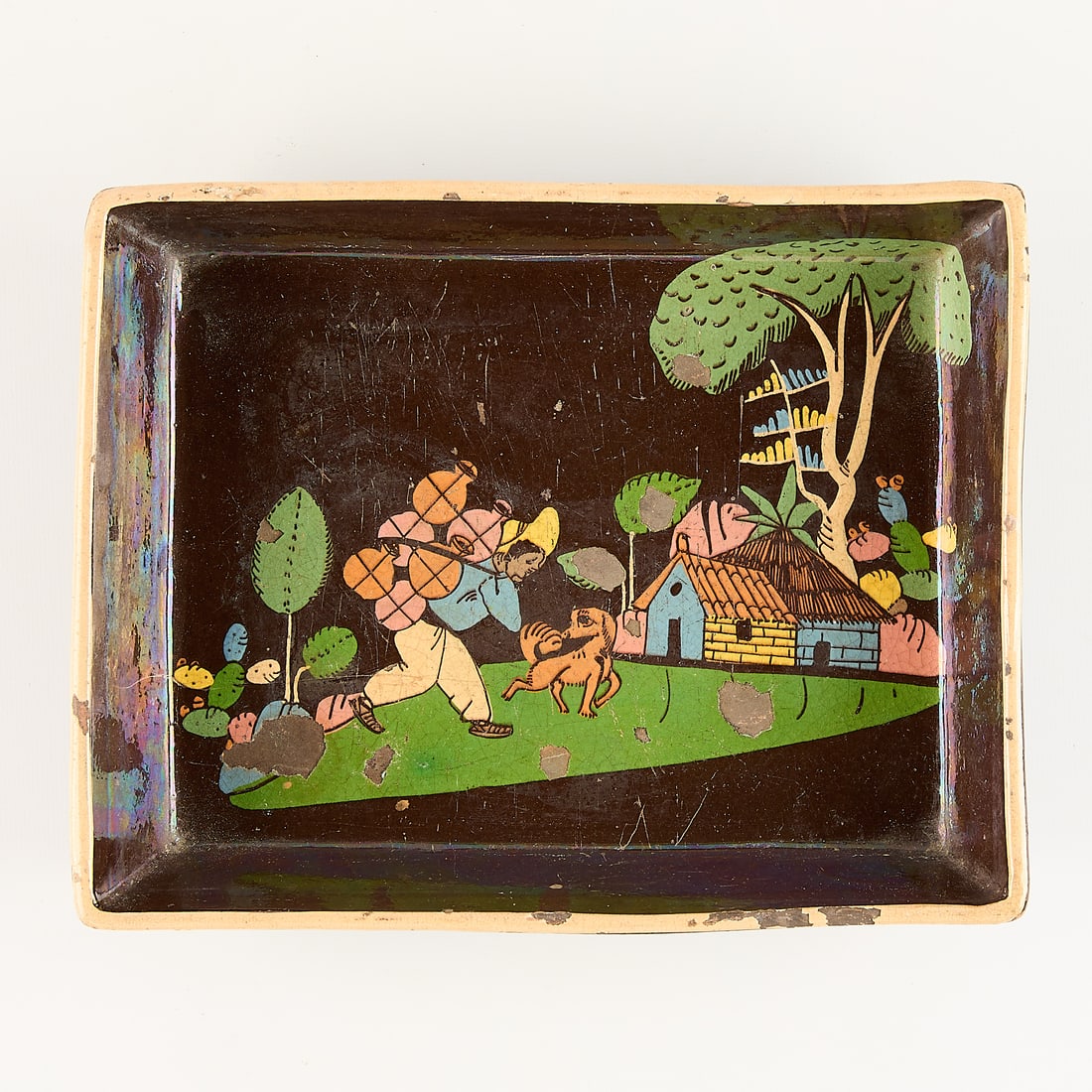 Mexican Tlaquepaque Black Rectangular Ceramic Tray: Mexican Tlaquepaque ceramic rectangular tray, plate, or dish. Depicting a figure burdened with ceramics walking through a landscape. Enamel losses.Height: 2 in x width: 10 1/2 in x depth: 8 1/4 in.