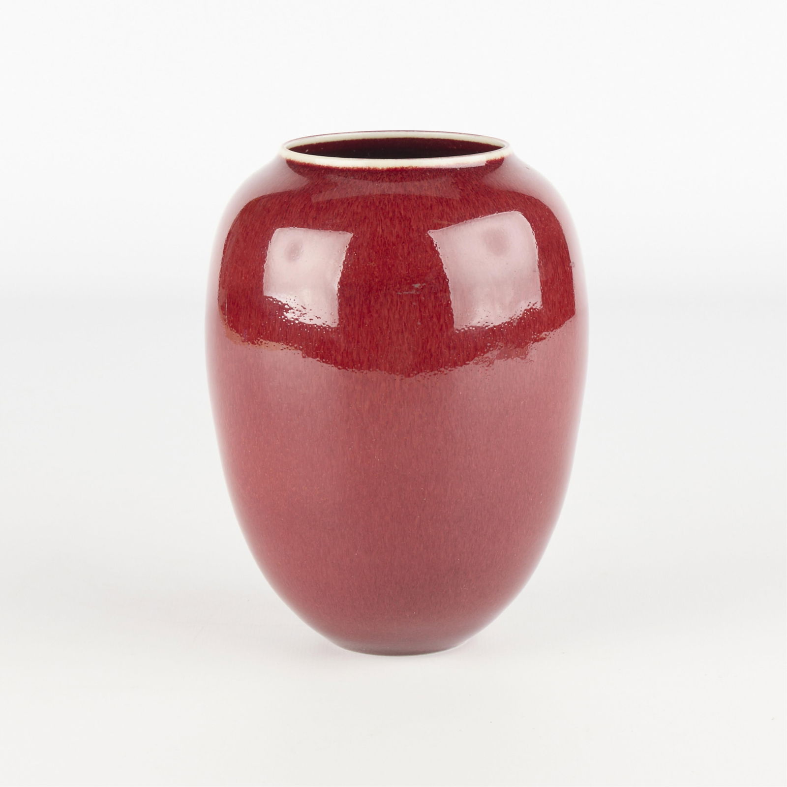 Ceramic Porcelain Oxblood Sang de Boeuf Vase: Studio pottery porcelain vase with rich red oxblood or sang-de-boeuf glaze. Illegible signature, possibly "Holm," and dated 1987 along the underside.Height: 6 3/4 in x diameter: 4 1/2 in.