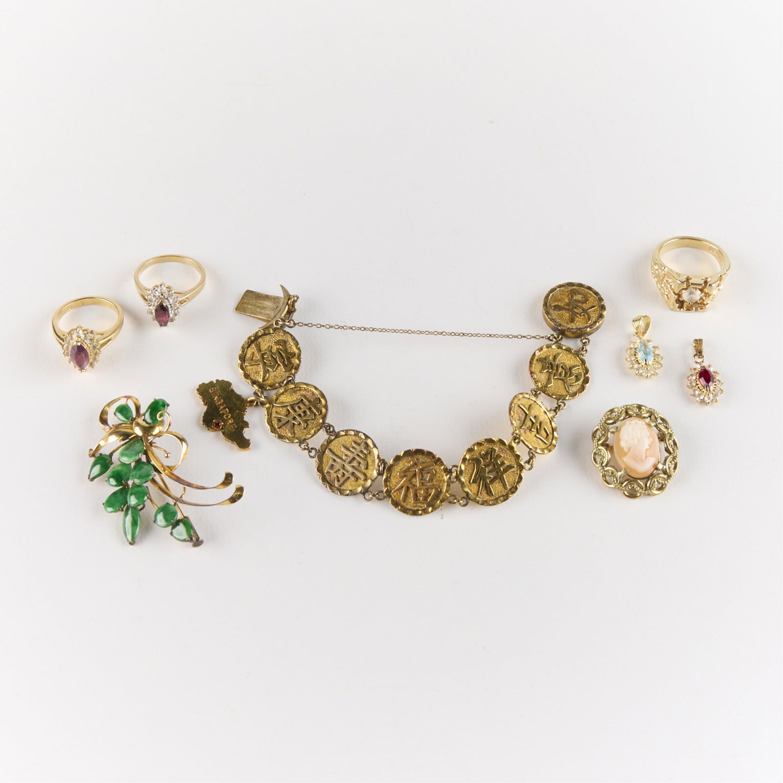 8 Pcs Gold-Plated Jewelry: Group of eight gold-plated jewelry pieces. Including one Art Nouveau floral brooch pin, marked illegibly, one Chinese medallion bracelet with Singapore charm, one cameo brooch or pendant, two gemstone