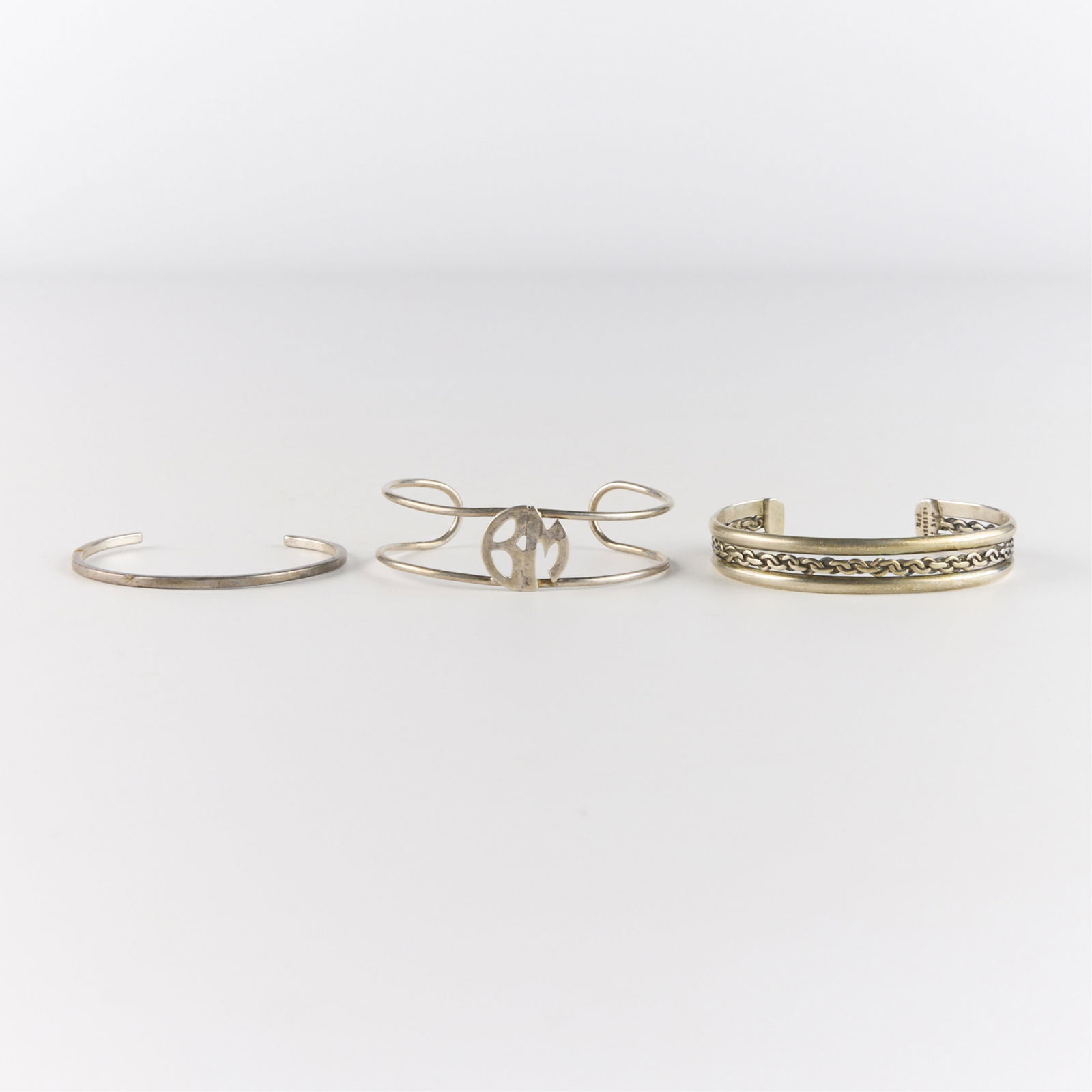 3 Sterling Silver Cuff Bracelets 1.476 ozt: Including one 925 sterling cuff with intricate filigree, one 925 sterling cuff with central WB monogram, and one Murphy sterling silver cuff,Diameter ranges from 2 1/4 in to 2 1/2 in. Gross weight: 1.