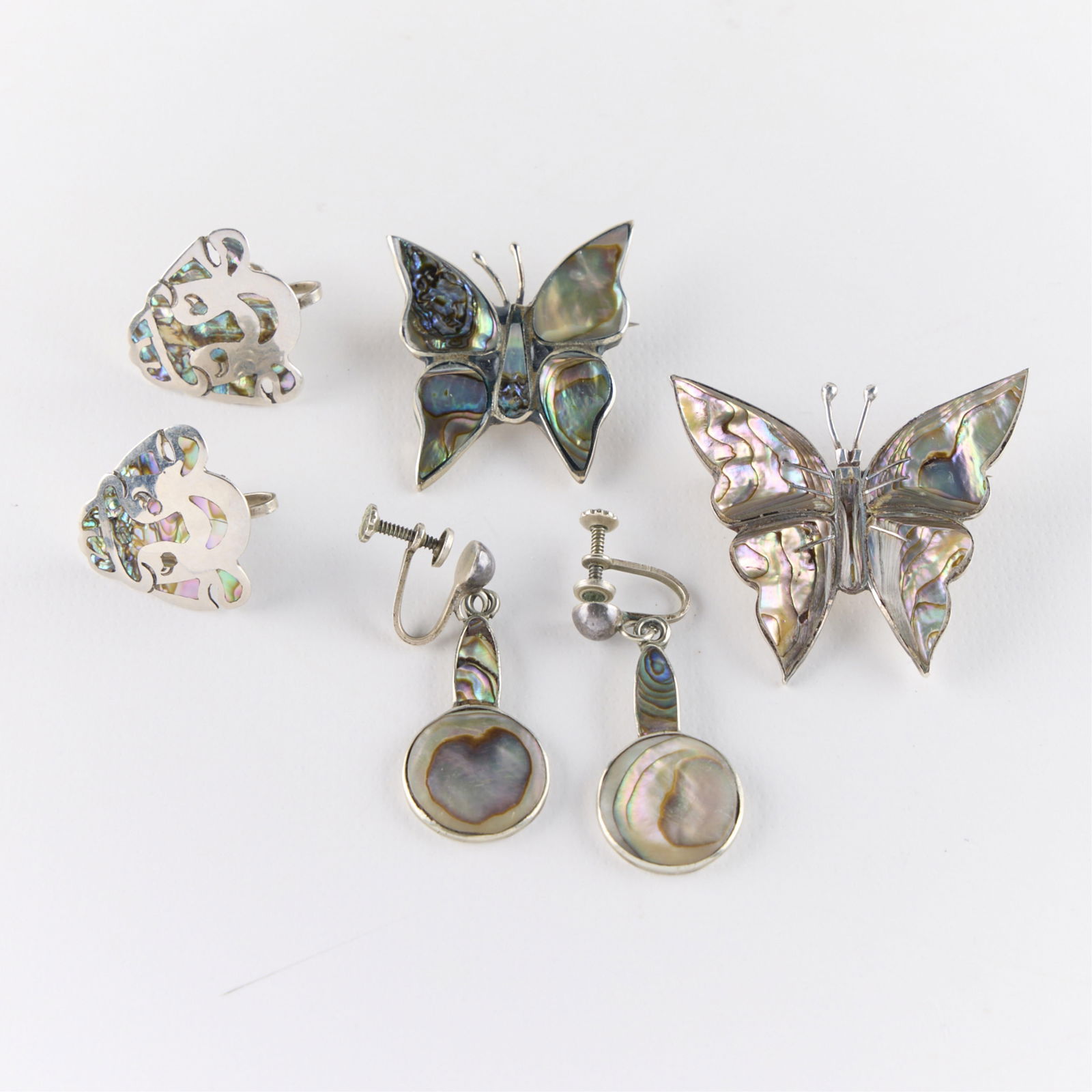 4 Pcs Mexican Sterling & MoP Jewelry: Including two brooch pins in the form of butterflies, and two pairs of earrings. Each with Mother-of-Pearl or abalone shell inlay. All marked. Gross weight: 27.82 g.
