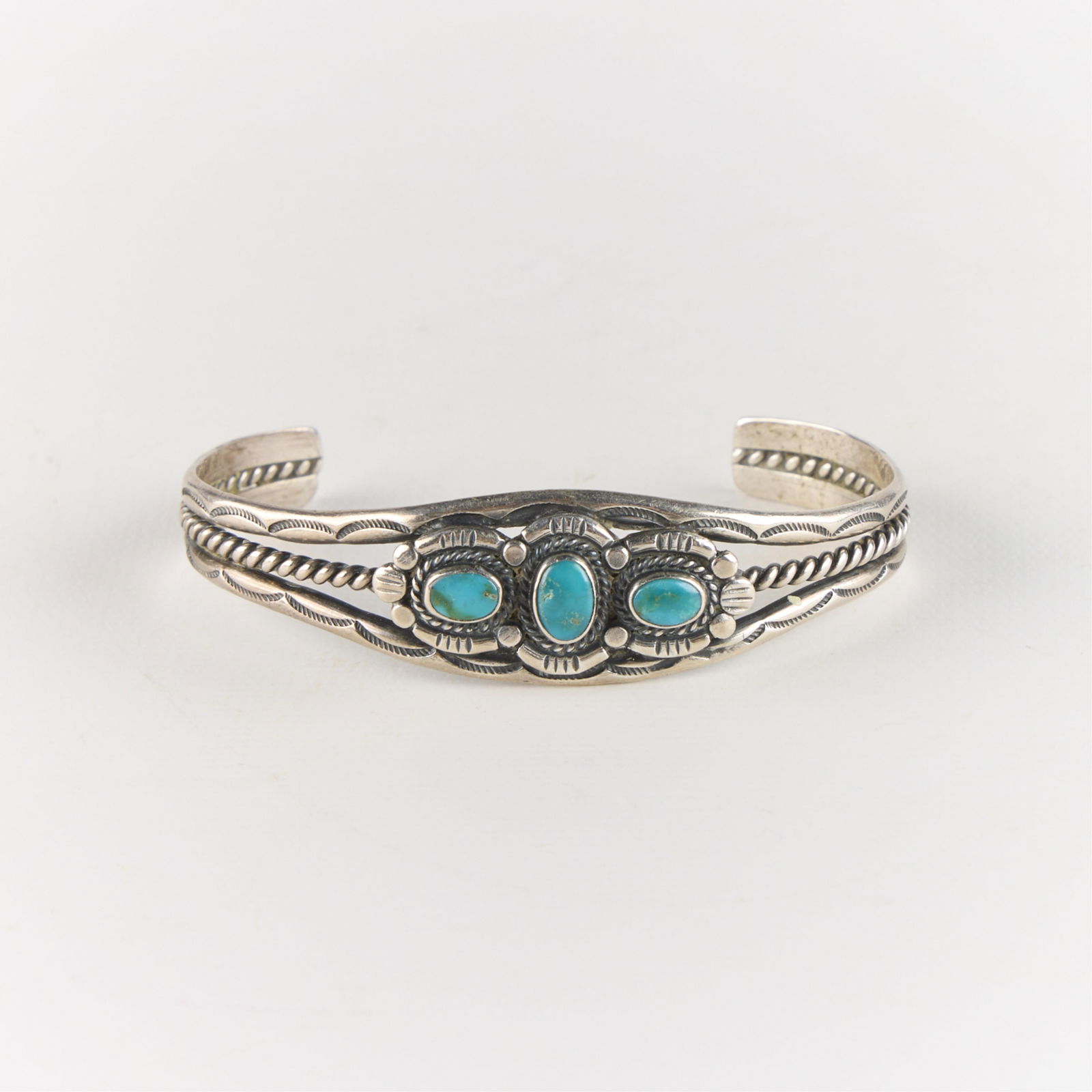 Vtg Southwest Silver & Turquoise Cuff Bracelet: Vintage Southwest-style, possibly Navajo, silver cuff bracelet with three inlaid turquoise stones and intricate filigree. Unmarked, tested silver. Diameter: 2 1/2 in. Weight: 21.53 g.