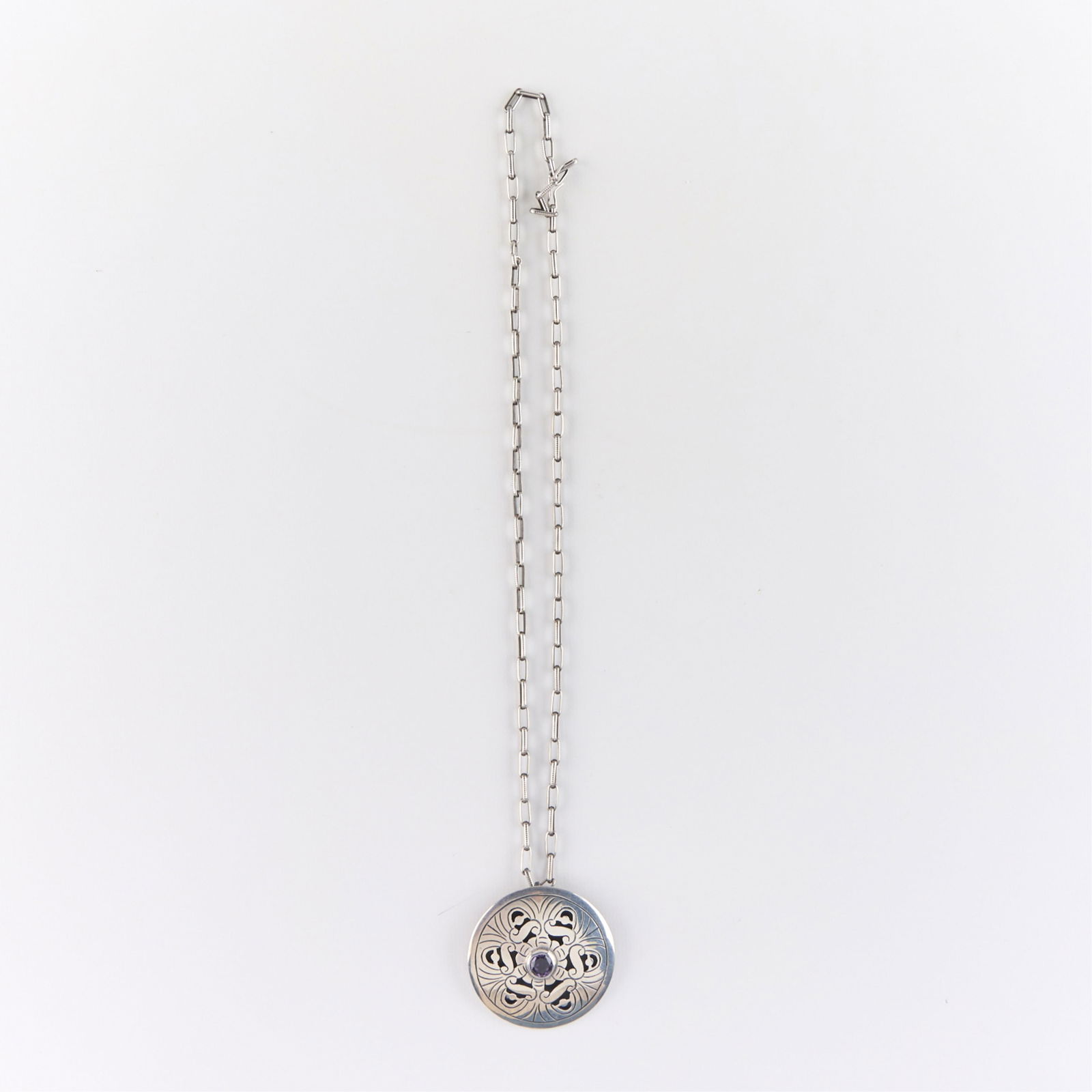 Taxco Mexican Sterling Silver & Amethyst Necklace: Taxco Mexican 925 sterling silver necklace with pierced floral design and central amethyst. Marked. Length: 25 in. Weight: 46.49 g.