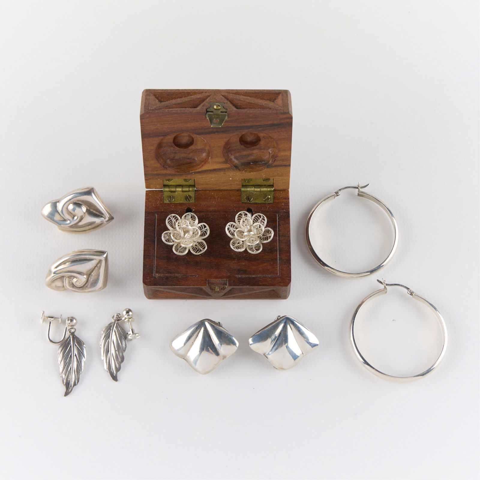 5 Pairs Mexican & Other Sterling Silver Earrings: Group of five pairs of sterling silver earrings. Including one pair of hoops, one pair of dangle earrings in the form of leaves or feathers, and three pairs of Mexican sterling silver earrings,
