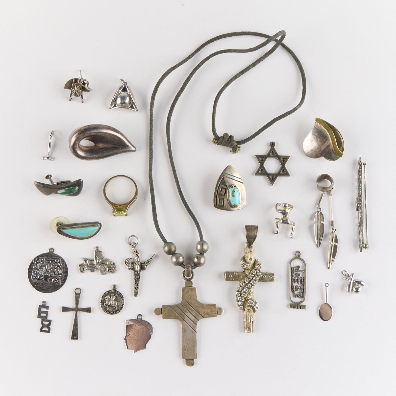 25 Sterling, Taxco, & Silver Charms & Pendants: Group of 25 assorted sterling, Mexican taxco, and silver charms, brooch pins, and pendants. Including 925 sterling Star of David charm, 925 sterling dagger with intricate filigree charm, 925 sterling