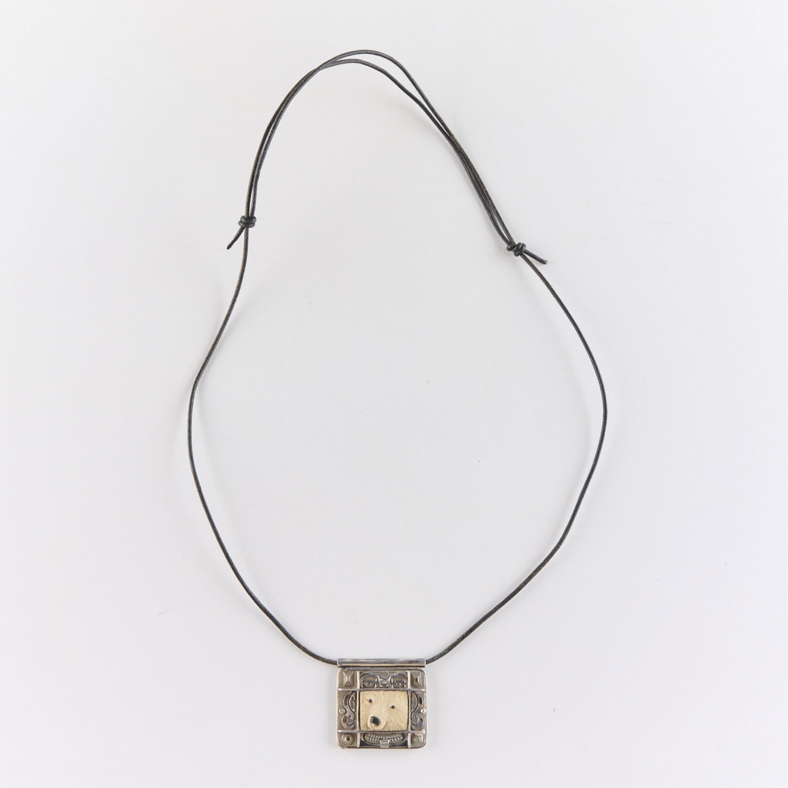 Zelandia Designs Sterling Polar Bear Locket: Zelandia Designs Sterling silver locket with polar bear motif. Marked along the interior. On a leather thong with slide knots to adjust length. Gross weight: 30.9 g.