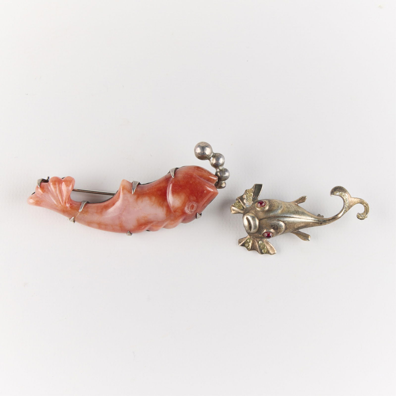 2 Vintage Sterling Silver & Coral Fish Brooches: Group of two sterling silver brooch pins in the form of fish. Including one Mexican silver brooch composed of polished coral and one sterling brooch with inlaid stones. Each marked. (Shipping