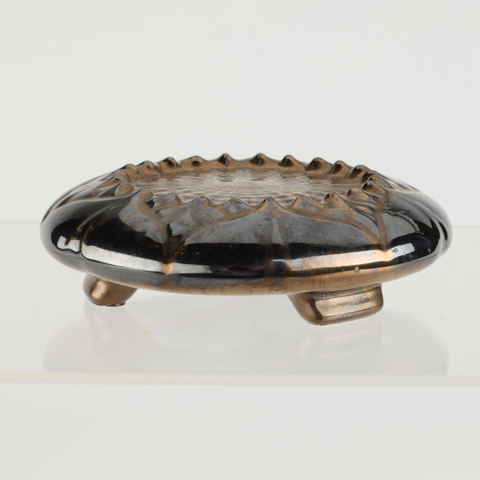 Attr. A&E Tile Co. Arts & Crafts Sunflower Trivet: Attributed to A&E Tile Company, Ohio. Arts & Crafts-era footed or raised trivet depicting a sunflower motif. Executed in a bronze-toned metallic glaze. Height: 1 1/4 in x diameter: 4 in.