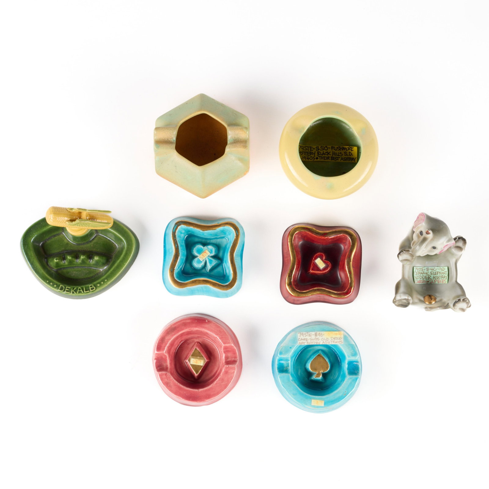 8 Vintage Ceramic Ashtrays Incl. Rosemeade: Group of eight assorted vintage ceramic art pottery ashtrays. Including a set of four ashtrays in the form of card suits, one Rushmore Pottery Black Hills ashtray, one Rosemeade Pottery Dekalb corn ad