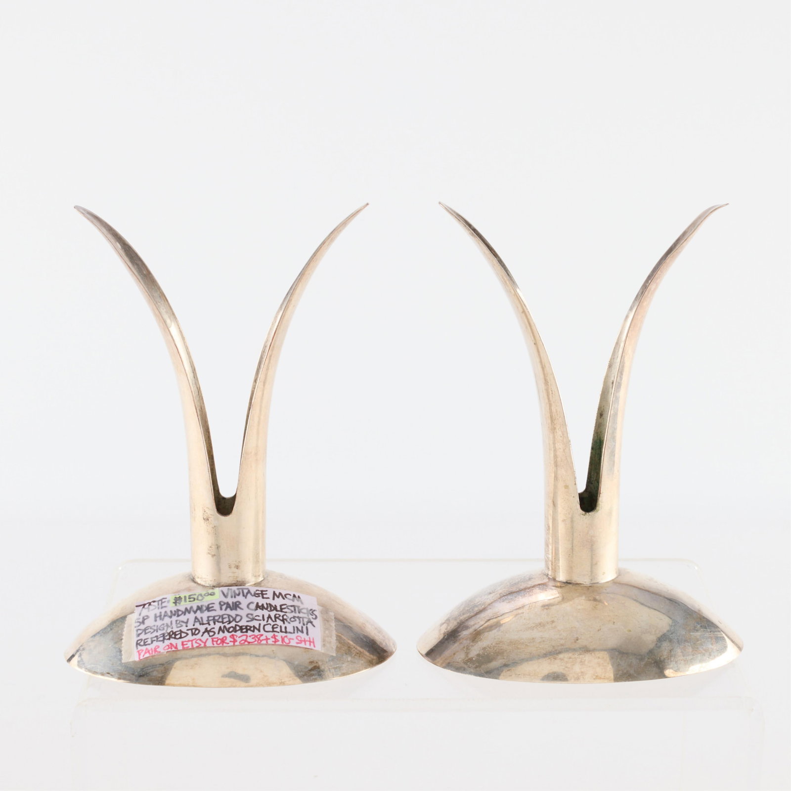 2 Alfred Sciarrotta MCM Silverplate Candlesticks: Alfred Sciarrotta (Italian-American, 1907-1985). Pair of mid-century modern pronged silver plate candlesticks or candle holders. Each marked along the underside.Height: 6 in x width: 4 in x depth: 2 3