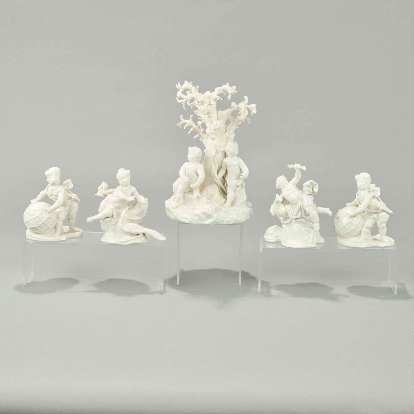 5 Nymphenburg Porcelain Cherub Putti Figurines: Nymphenburg Porcelain Manufactory, Germany. Group of five porcelain figurines. Including two pairs of angel or putti figures and one larger figural group. All marked along the underside.(Smaller Cheru