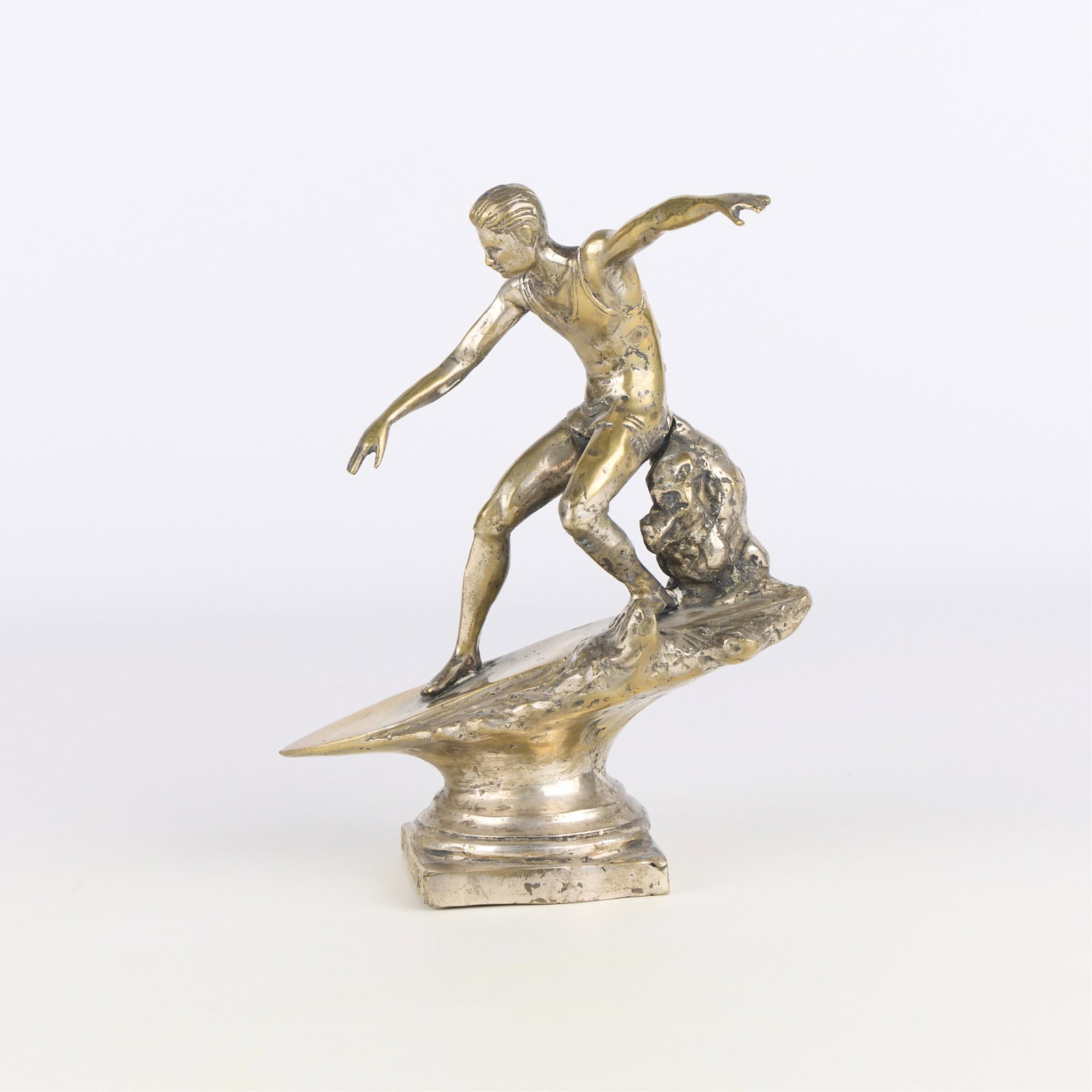 Art Deco "Surfing the Nations" Trophy ca. 1920-30: Art Deco cast metal sculptural trophy depicting a surfing male figure, ca. 1920-1930. Impressed "Surfing the Nations" along the footrim. Height: 9 in x width: 7 1/2 in x depth: 4 in.