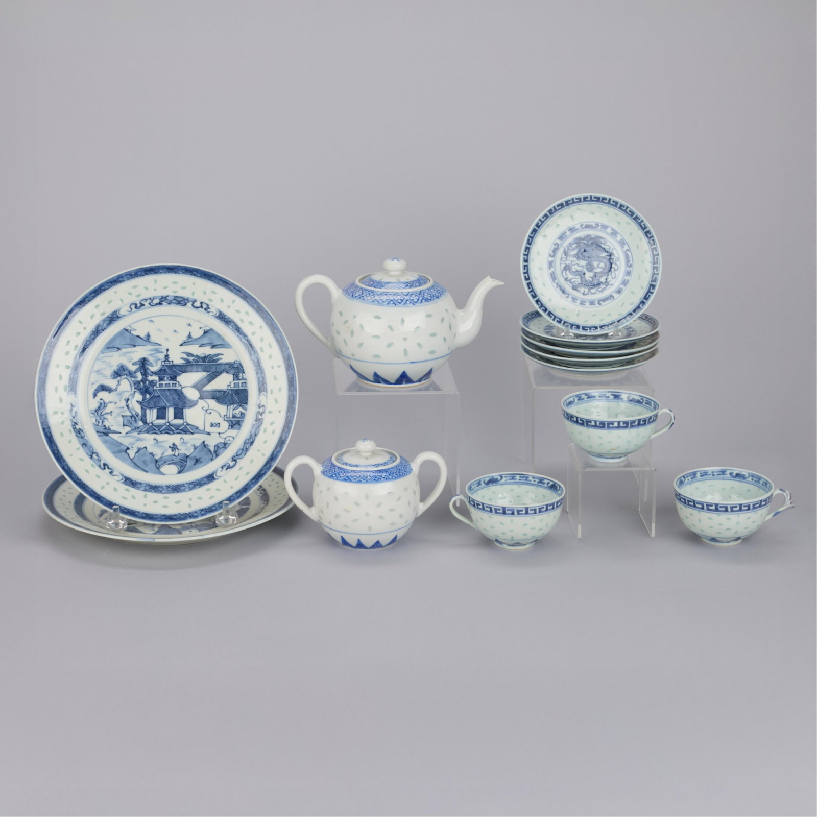 12 Pc Rice Pattern Chinese Porcelain: Including one teapot, one sugar bowl, three teacups, five saucers, and two large plates. The two larger plates marked "China" in blue glaze along the underside; the remaining pieces with a four charac