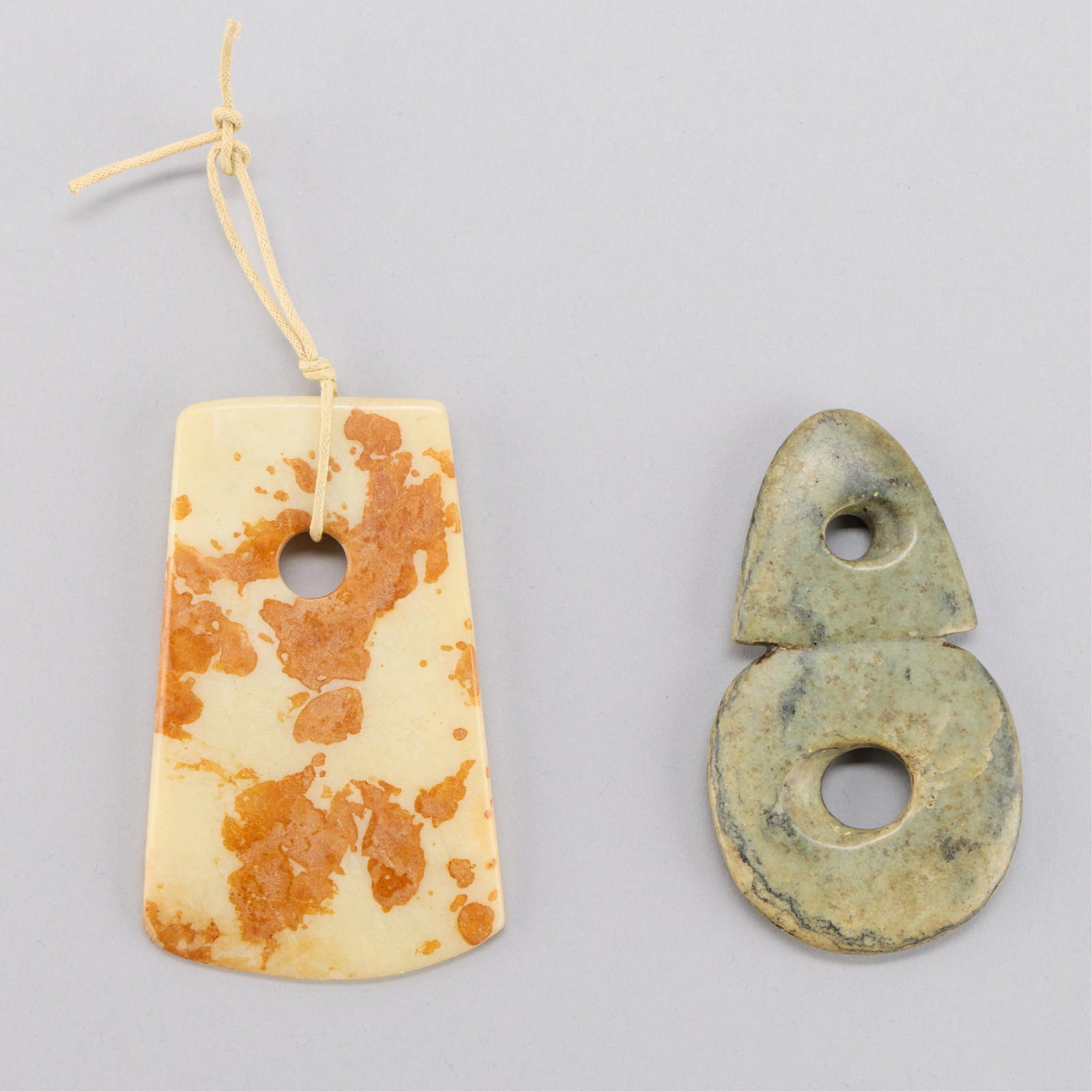 Chinese Jade Double Bi & Ax Head: Group of two Chinese archaic style jade or jadeite carvings. One of an axe head and one of a double-bi form. (Double bi) height: 4 in x width: 2 1/4 in x depth: 1/4 in. Weight: 87.0 g. (Ax) height: 2 