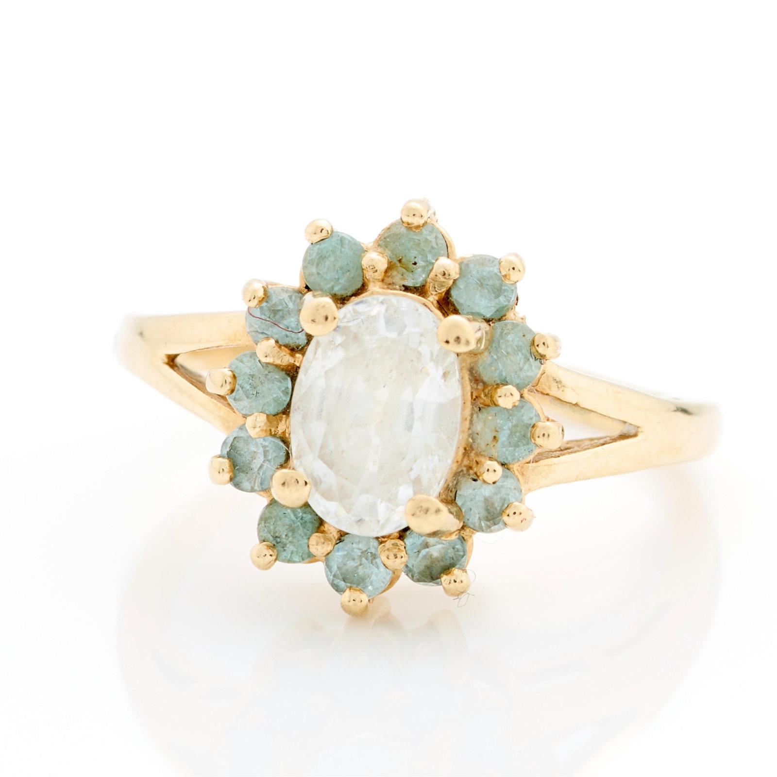 10k Yellow Gold Topaz Ring Sz 5.25: 10k yellow gold ring set with central oval cut white stone, likely white topaz surrounded by smaller blue stones, also likely topaz. Marked 10k along the interior shank. Ring size: 5 1/4 US. Gross wei