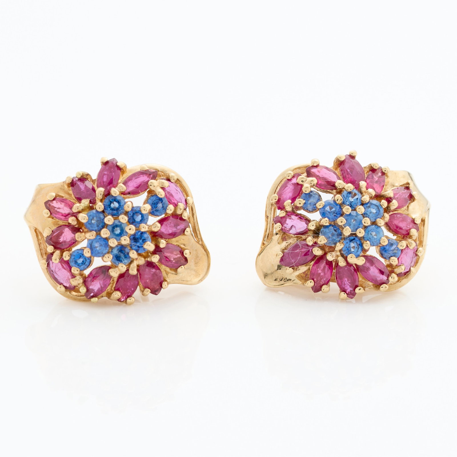 10k Pr Floral Cluster Pink & Blue Stone Earrings: Pair of 10k yellow gold floral cluster earrings set with rubies and sapphires. Marked 10k along the interior. Gross weight: 5.24 g.