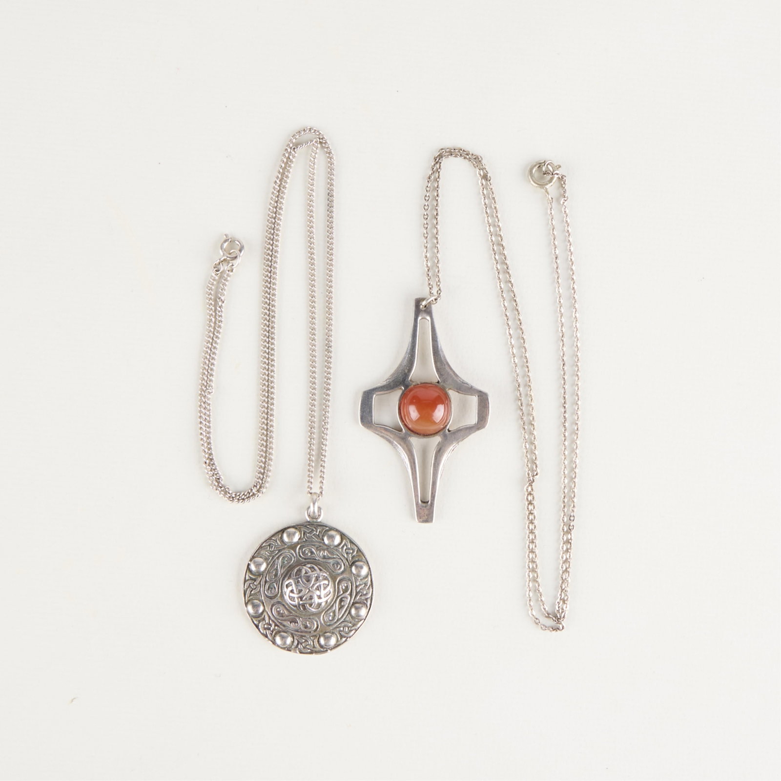 2 Scottish & English Silver Necklaces Incl. Iona: Group of two sterling necklaces. Including one Scottish pendant, marked "Iona" along the verso of pendant, and one English modernist necklace. Both with hallmarks. One chain marked sterling. (Modernis