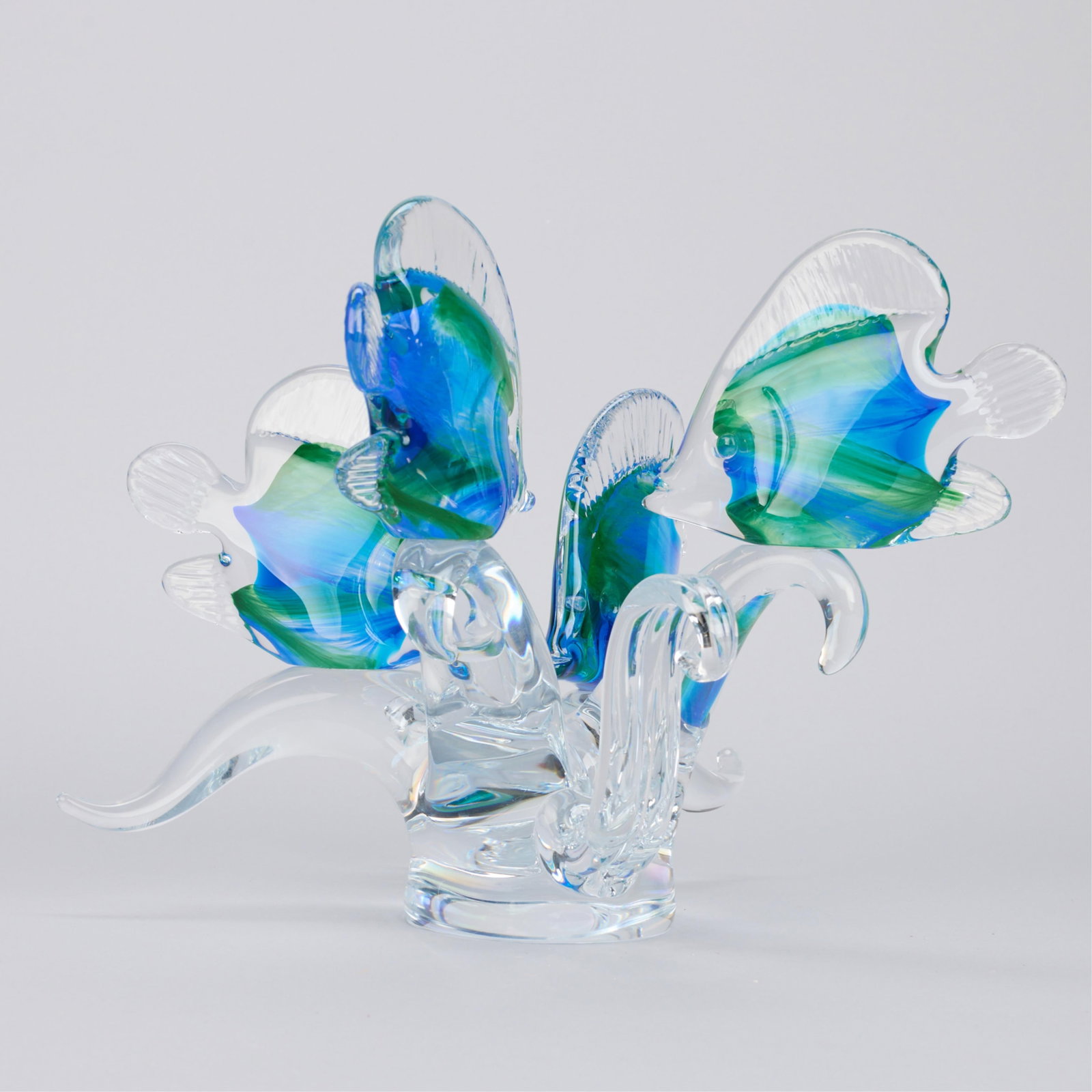 Blue & Green Glass Fish Sculpture: Glass fish sculpture in the Murano style. Depicting four vibrant blue and green angel fish swimming among clear glass seaweed. With a Sardinia crystal label. Incised illegible signature, titled "Bessi