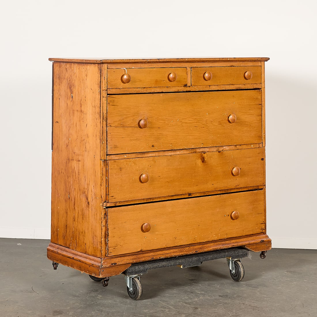 English Pine Wood Chest of Drawers Dresser: Antiqure English-style pine chest of drawers or dresser featuring a two-over-three drawer configuration atop rolling caster feet. Height: 39 1/2 in x width: 41 3/4 in x depth: 19 1/4 in.