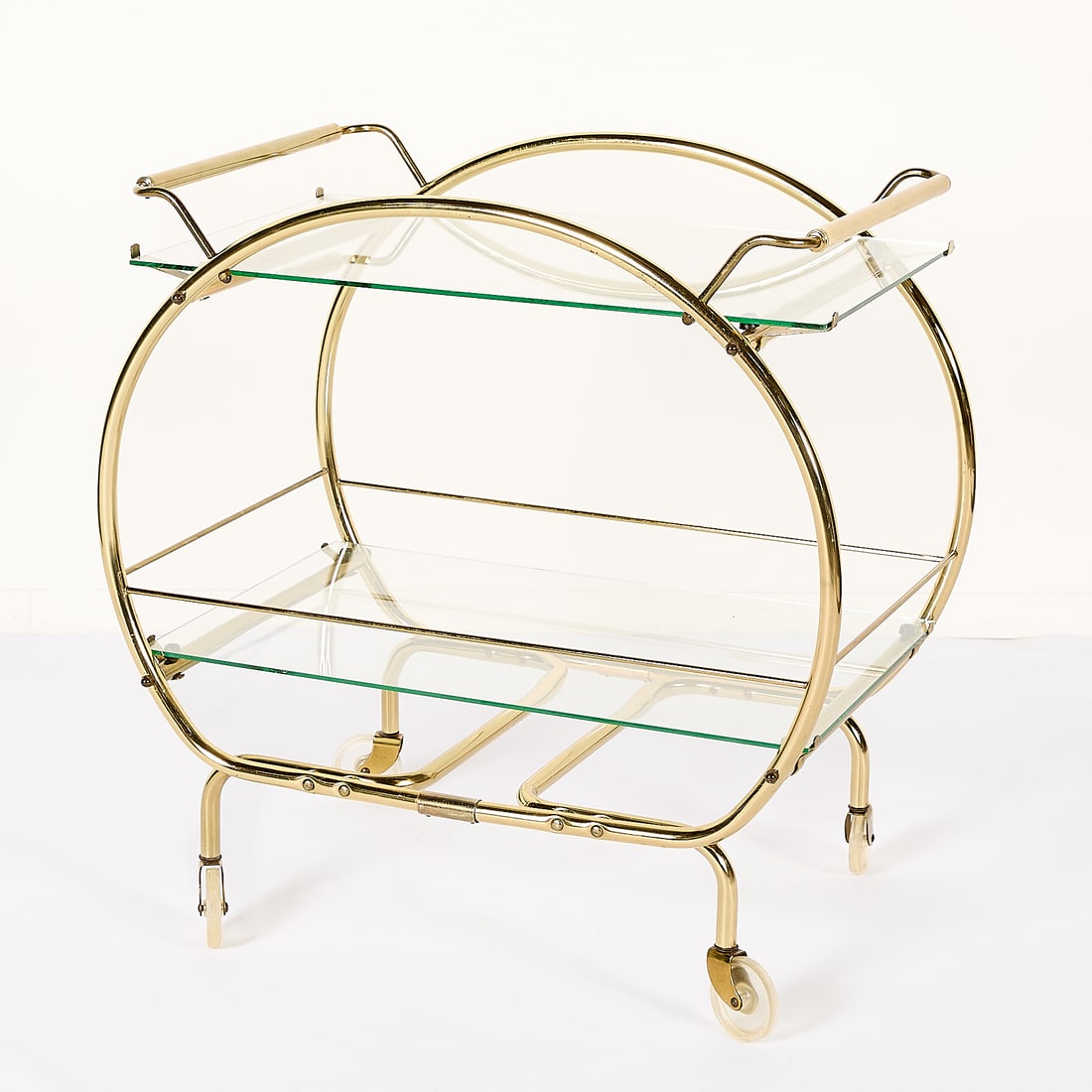 Vintage Art Deco MCM Bar Cart: Vintage Art Deco or mid-century modern bar cart with a rounded, gold-toned metal frame, two glass shelves, and rolling casters. Height: 28 3/4 in x width: 19 in x depth: 28 1/2 in.