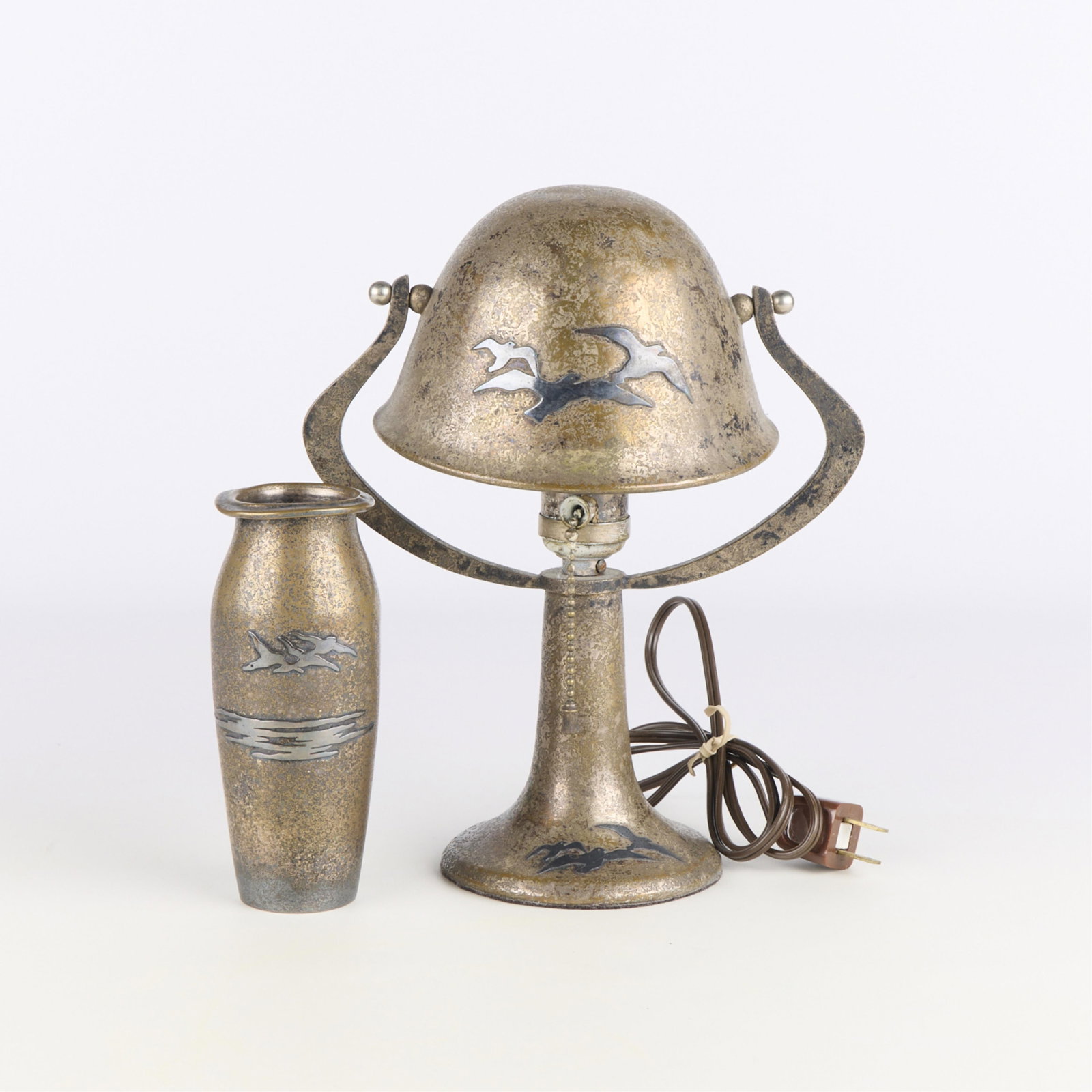 Silver Crest Heintz Arts & Crafts Bronze Lamp & Vase: Group of two Arts & Crafts bronze items with sterling silver overlay. Including one Smith Metal Arts Company Silver Crest bud vase, marked and dated 2004 along the underside, and one Heintz Art Metal 