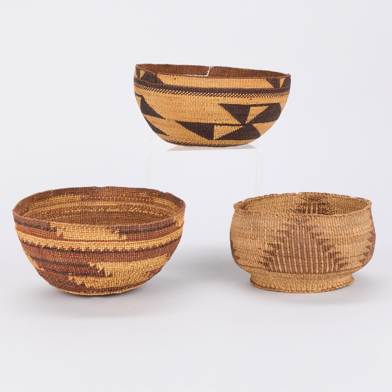 3 PNW Native American Klamath Coiled Baskets: Group of three Pacific Northwest Native American woven and coiled baskets. Likely Klamath. Height ranges from 3 1/4 in to 3 1/2 in; diameter ranges from 6 in to 7 in.