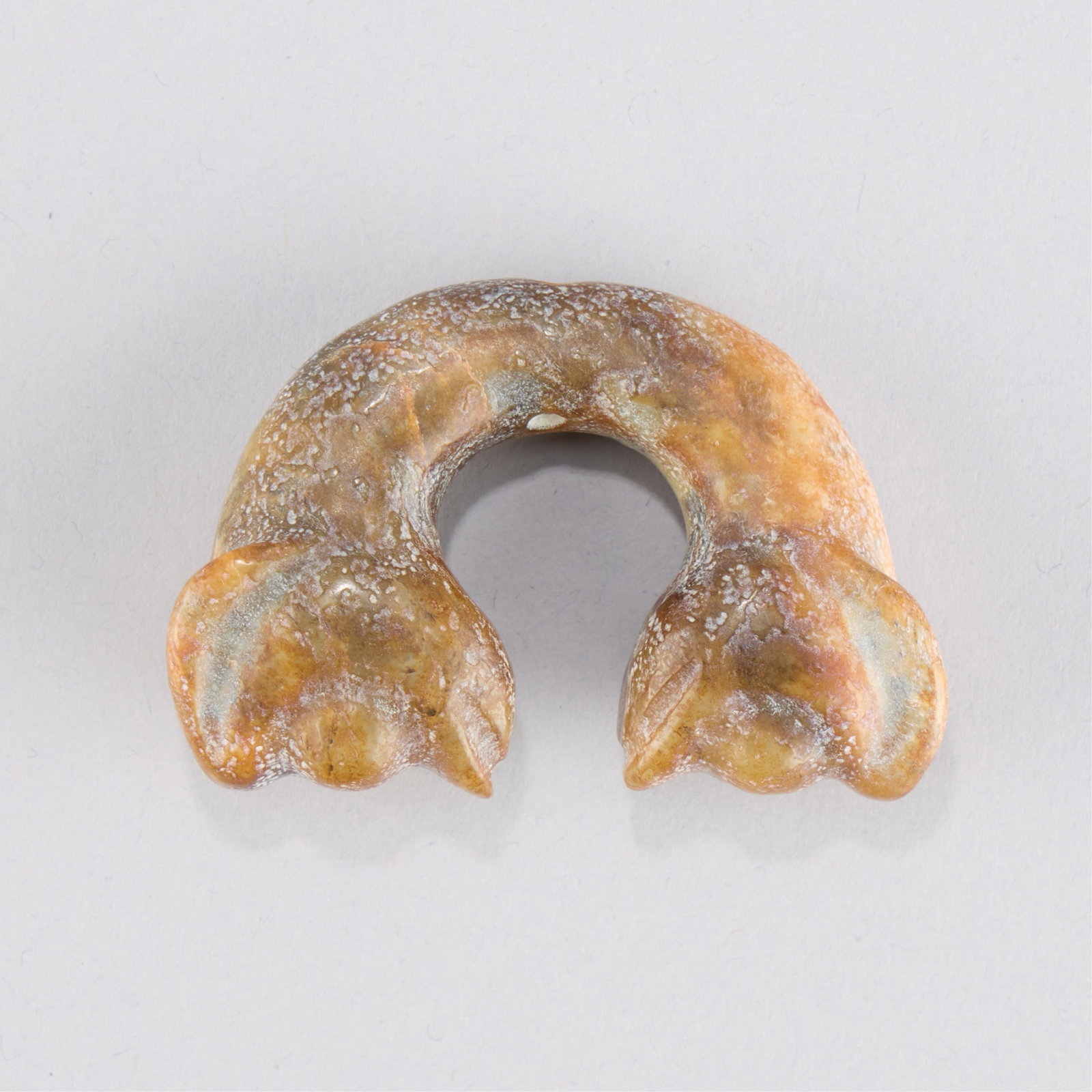Chinese Hongshan Style Jade Ram Carving: Archaistic Chinese Hongshan Culture style jade carving of a C-form terminating in two ram heads. Height: 1 1/2 in x width: 2 3/8 in x depth: 3/4 in. Weight: 51.76 g.