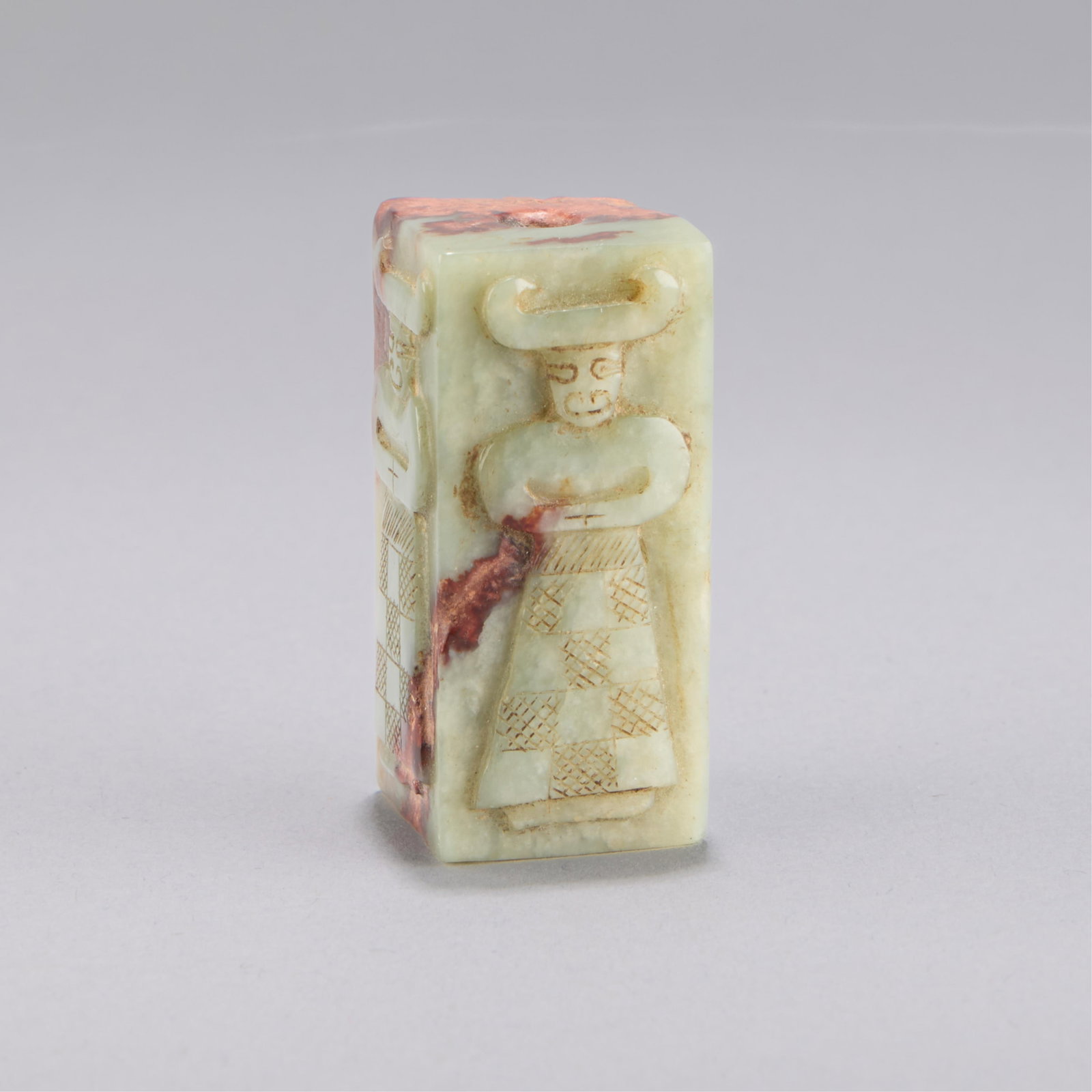Chinese Archaic Style Jade Bead: Chinese archaistic carved jade bead of rectangular form; each side carved with a figure in a taotie mask or possibly an anthropomorphic ox. Height: 2 in x width: 7/8 in x depth: 7/8 in. Weight: 70.44 