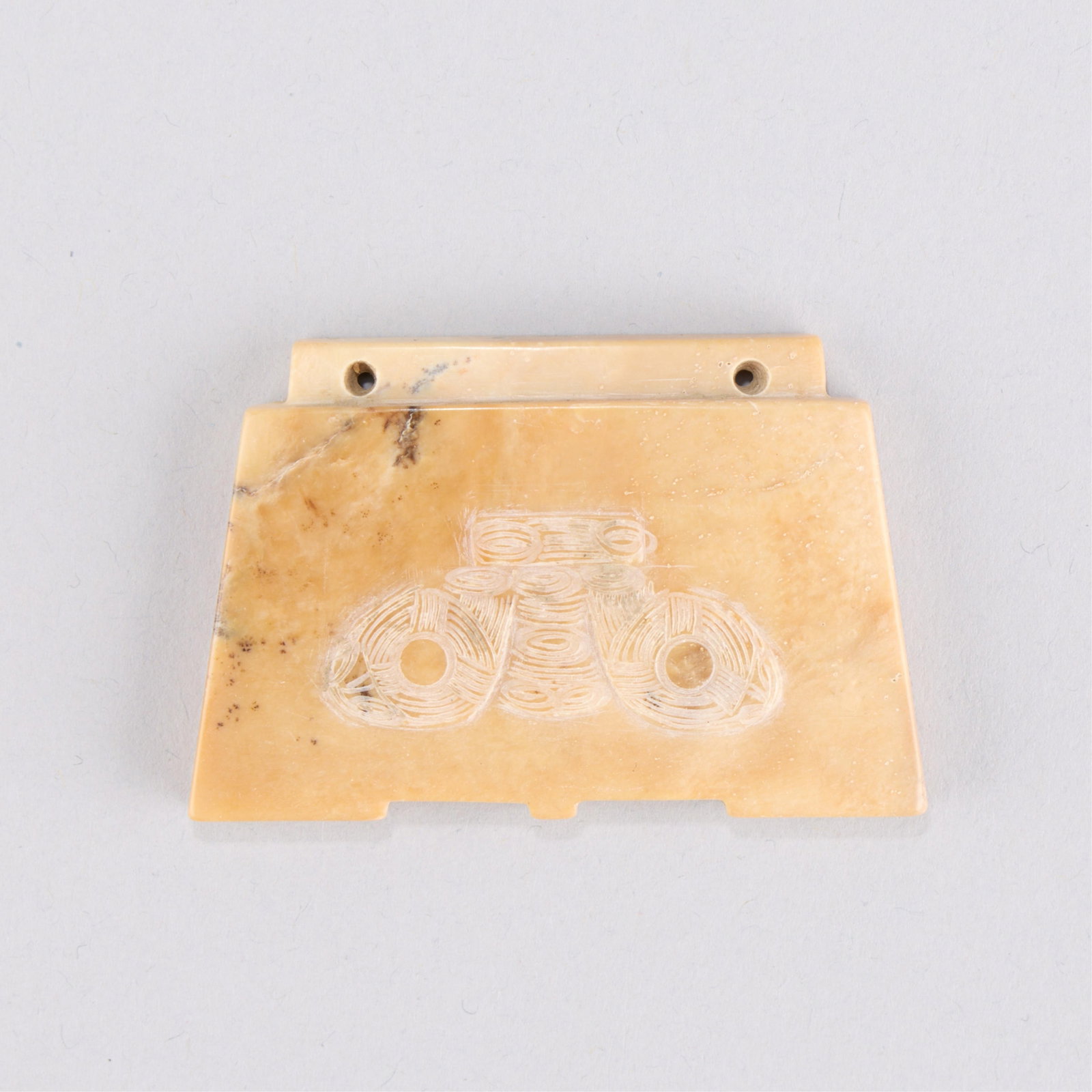 Chinese Liangzhu Style Jadeite Pendant: Chinese Liangzhu Culture archaistic style jade carving with a beast or mask form carved along one side. Height: 1 5/8 in x width: 2 3/8 in x depth: 1/8 in. Weight: 34.39 g.
