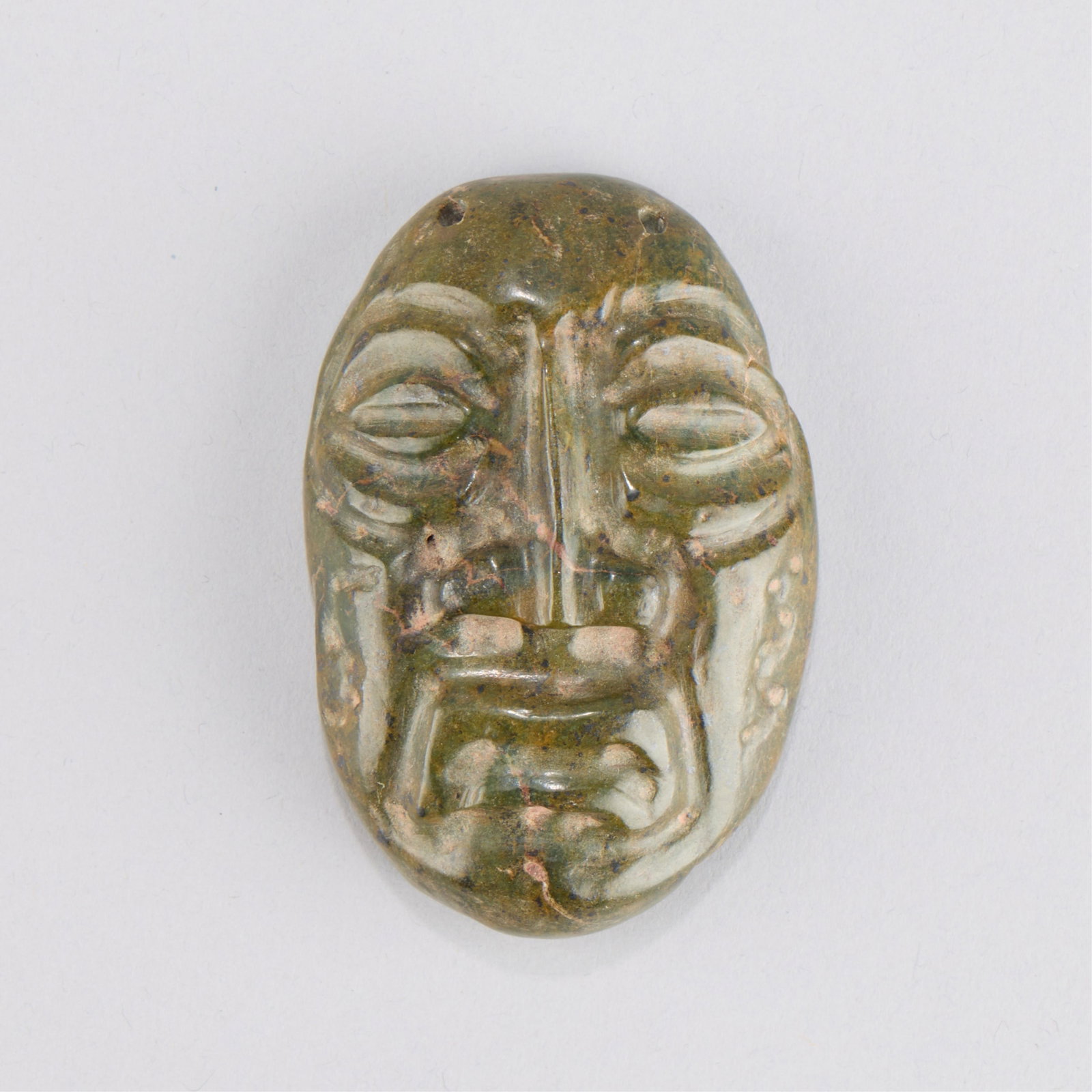 Chinese Hongshan Style Jade Mask: Archaistic Chinese Hongshan Culture style archaistic carved jade mask or head pendant. Height: 3 1/4 in x width: 2 1/4 in x depth: 1 in. Weight: 98.47 g.