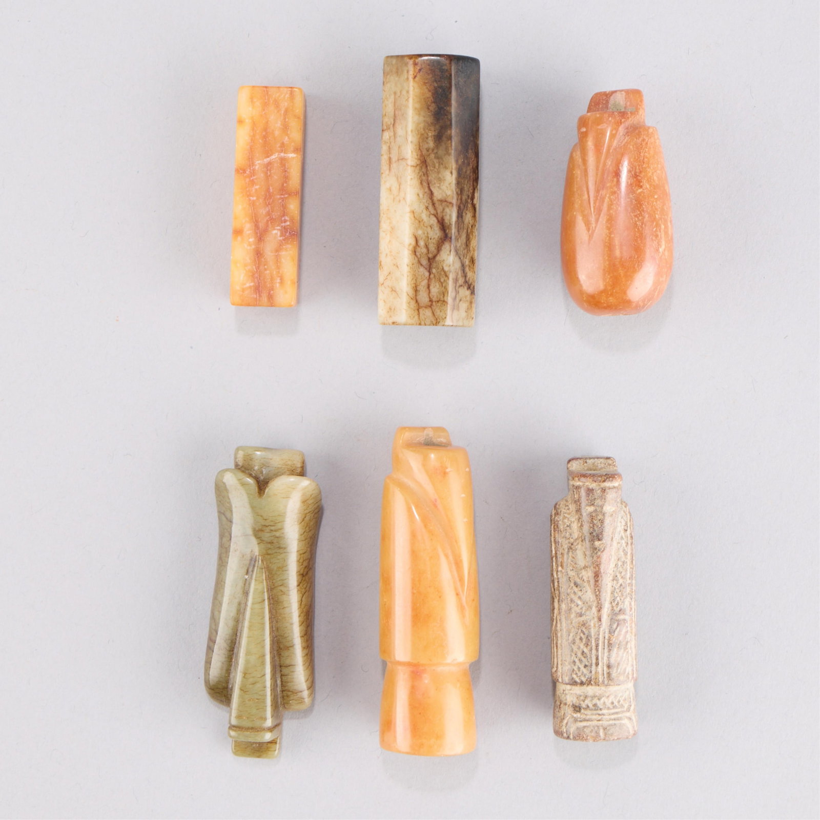 6 Chinese Jadeite Beads: Group of six Chinese jade or jadeite beads. Of archaistic style. Height ranges from 1 5/8 in to 2 1/4 in; width ranges from 3/8 in to 3/4 in; depth ranges from 3/8 in to 3/4 in. Gross weight of lot: 1